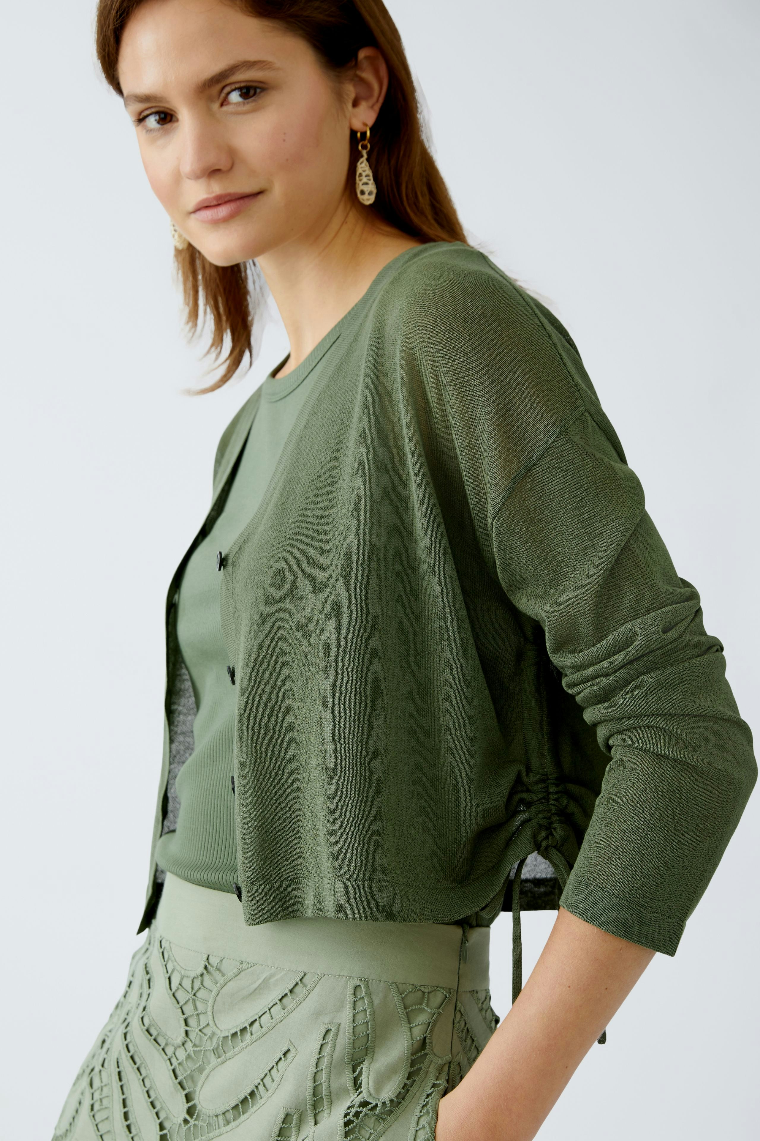 Stylish women's cardigan in soft green, featuring a relaxed fit and elegant design.