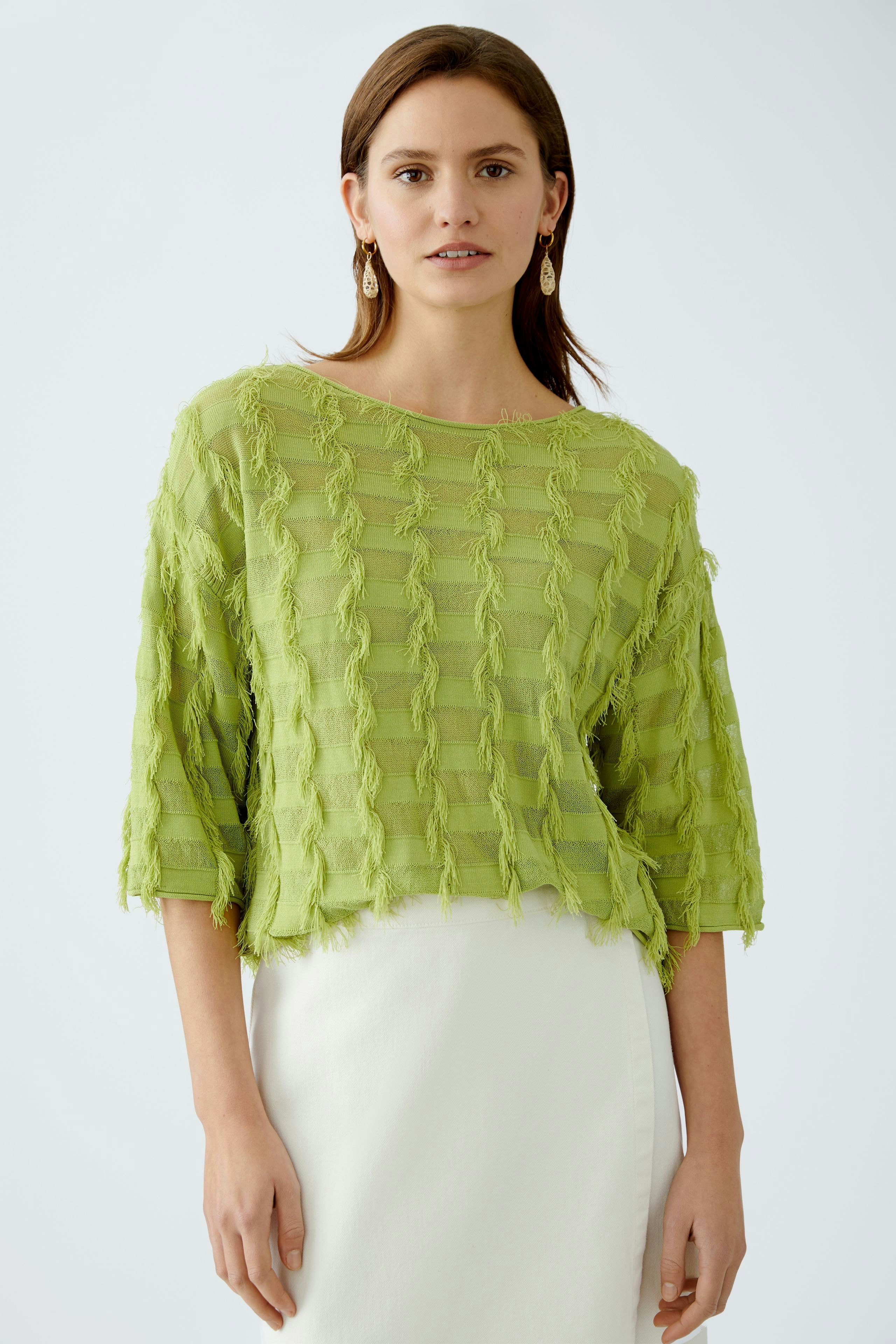 Stylish women's pullover: A woman in a light green textured pullover with a relaxed fit.