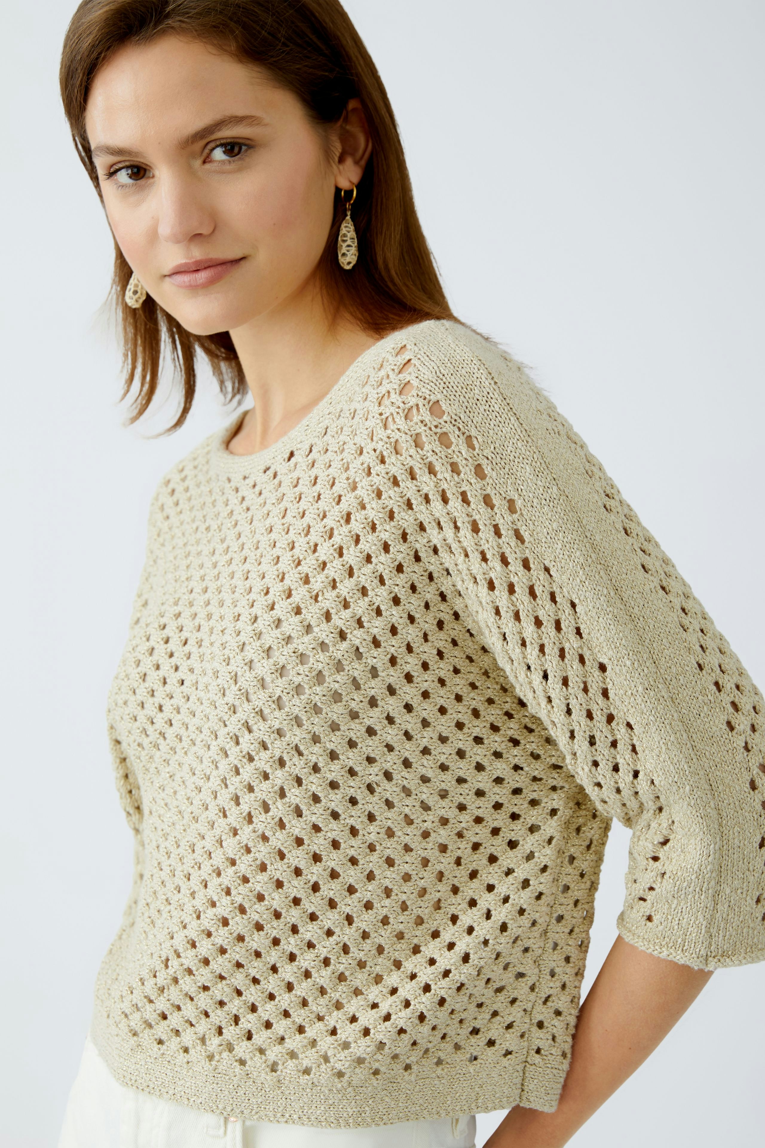 Stylish women's pullover: A woman in a light, airy knit pullover with a relaxed fit.