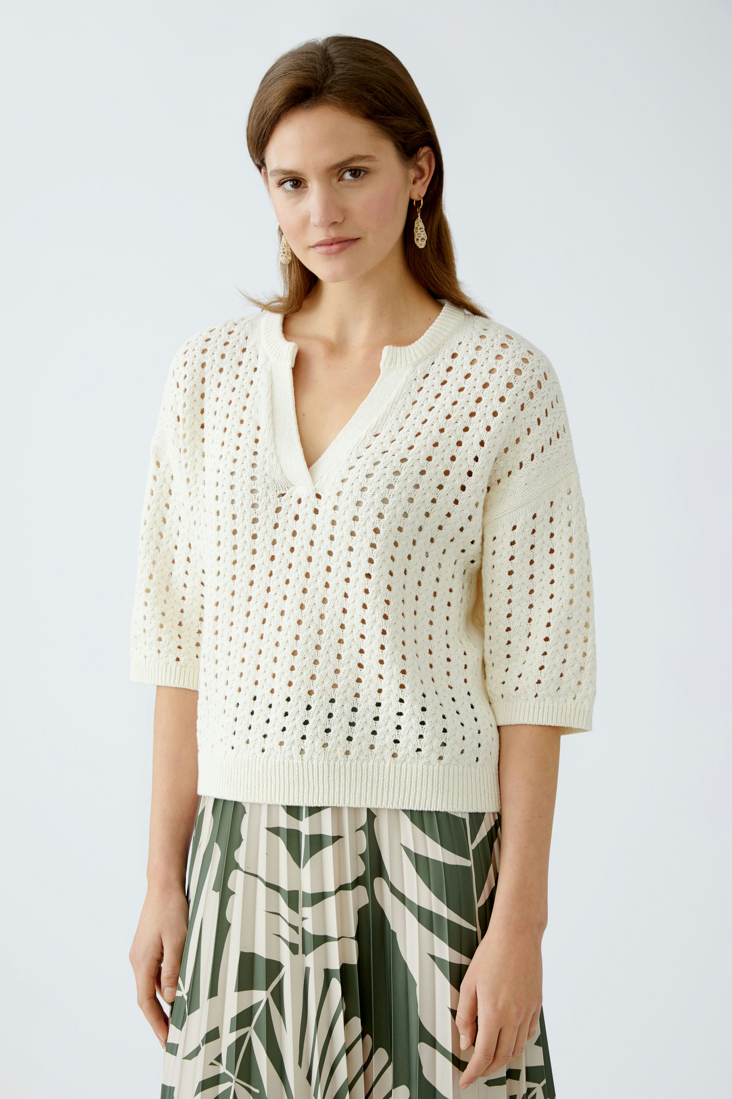 Stylish women's pullover: A woman in a cream open-knit pullover paired with a floral skirt.