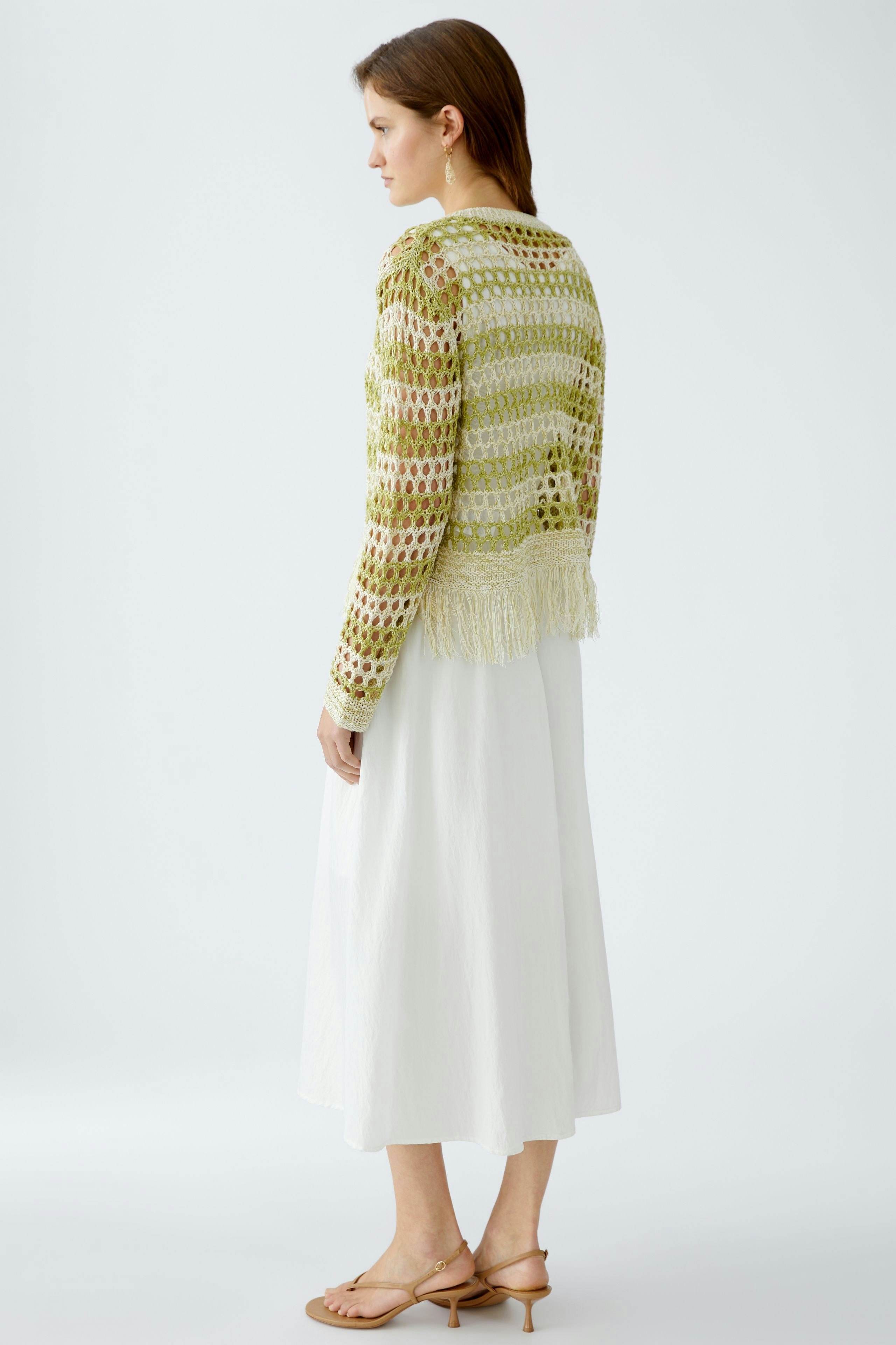 Damen-Pullover: Frau in einem hellgrünen, luftigen Strickpullover mit Fransen und lässigem Look.