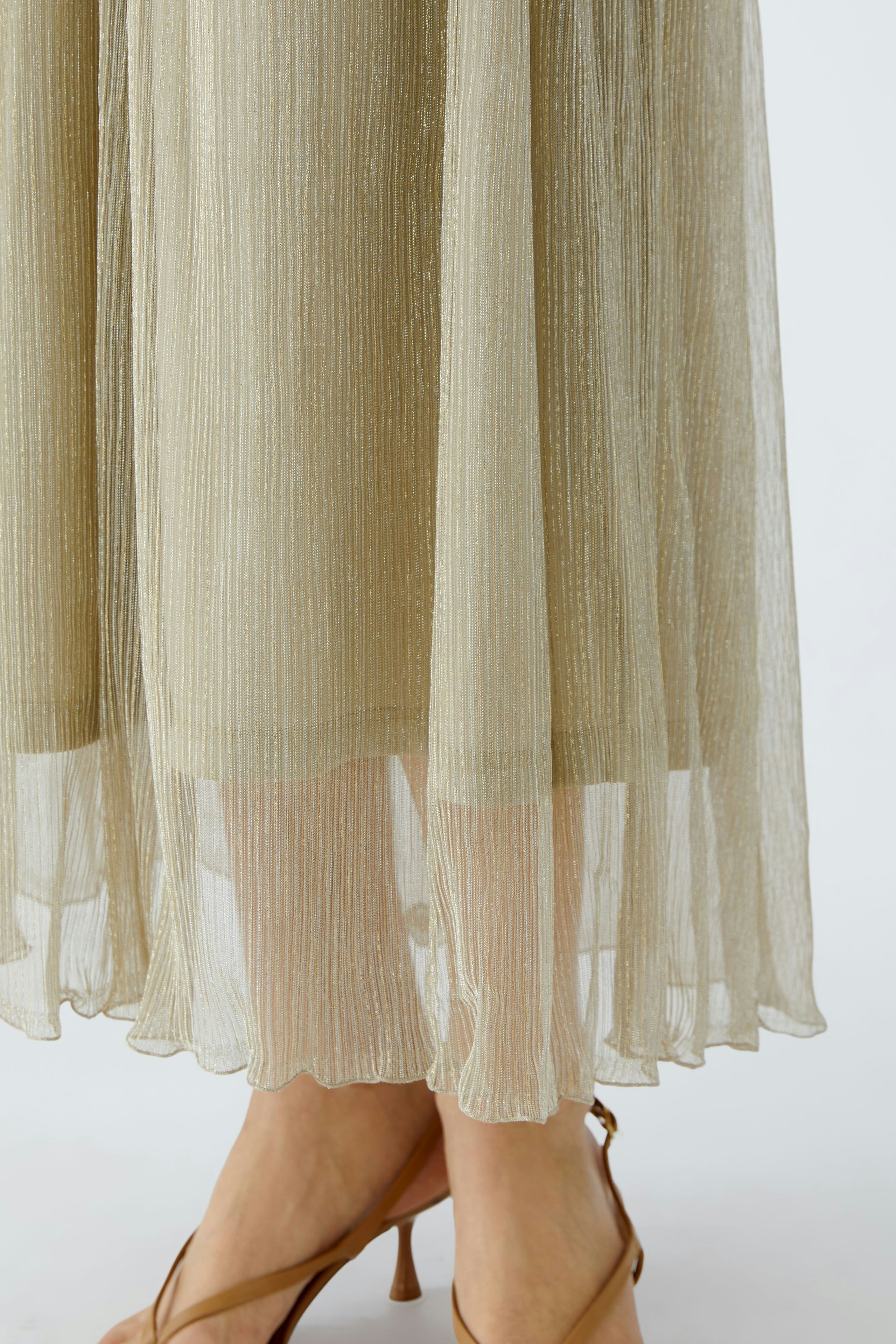 Elegant maxi skirt: A woman showcases a shimmering, flowing maxi skirt with a delicate hem.