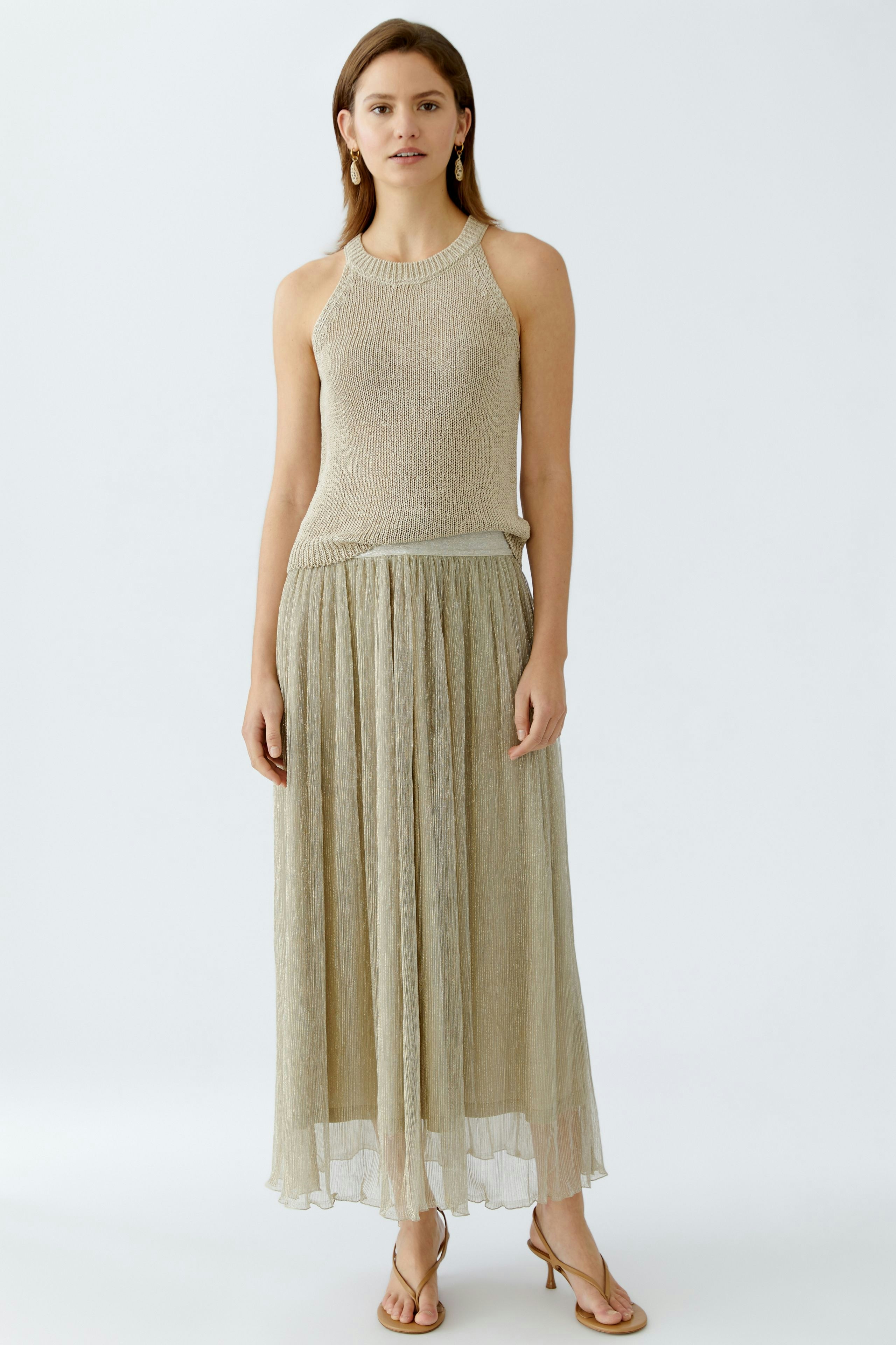 Elegant maxi skirt: A woman in a shimmering, floor-length skirt paired with a stylish top.