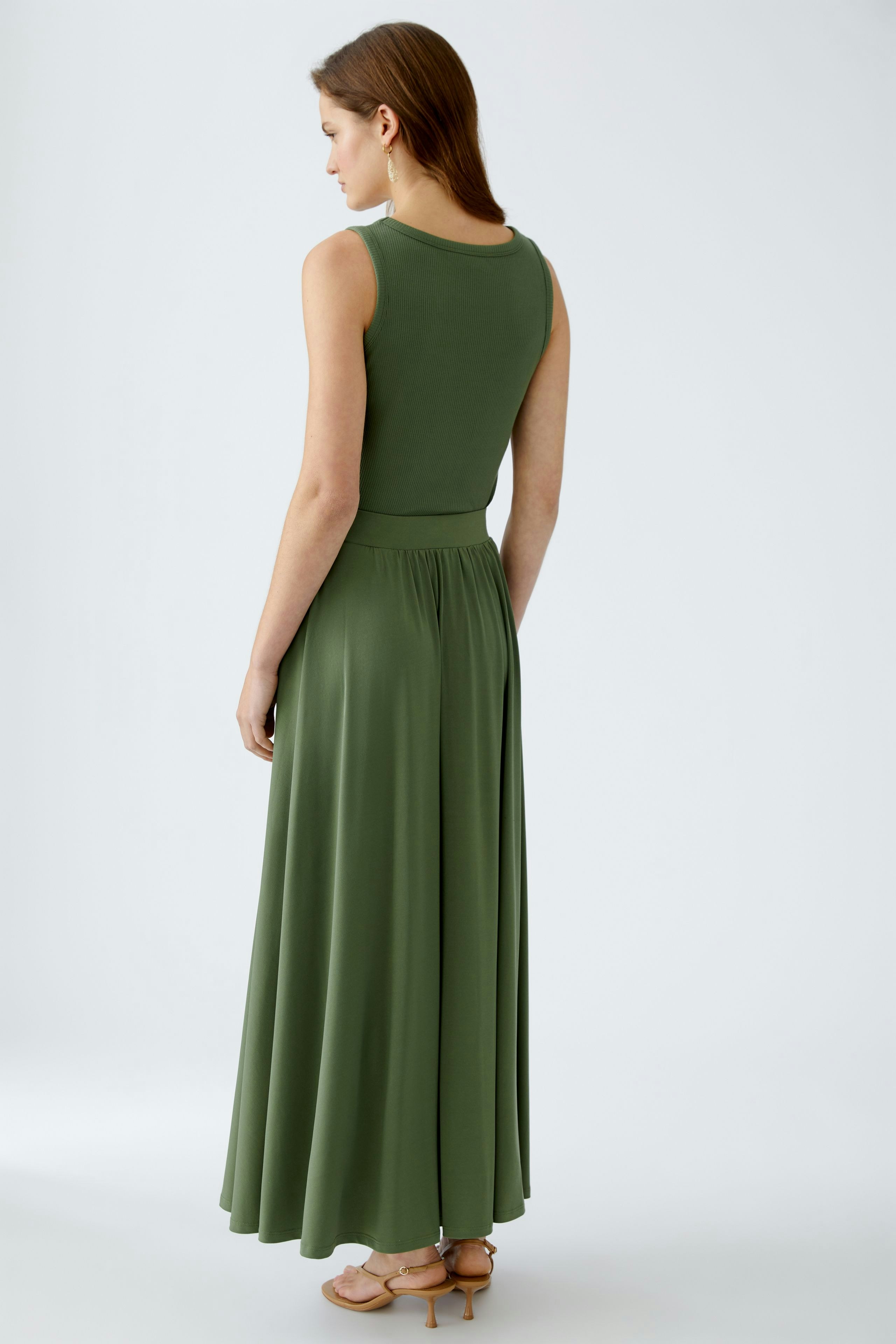 Eleganter A-Linien-Rock: Frau in grünem, fließendem Rock mit weitem Schnitt und elastischem Bund.