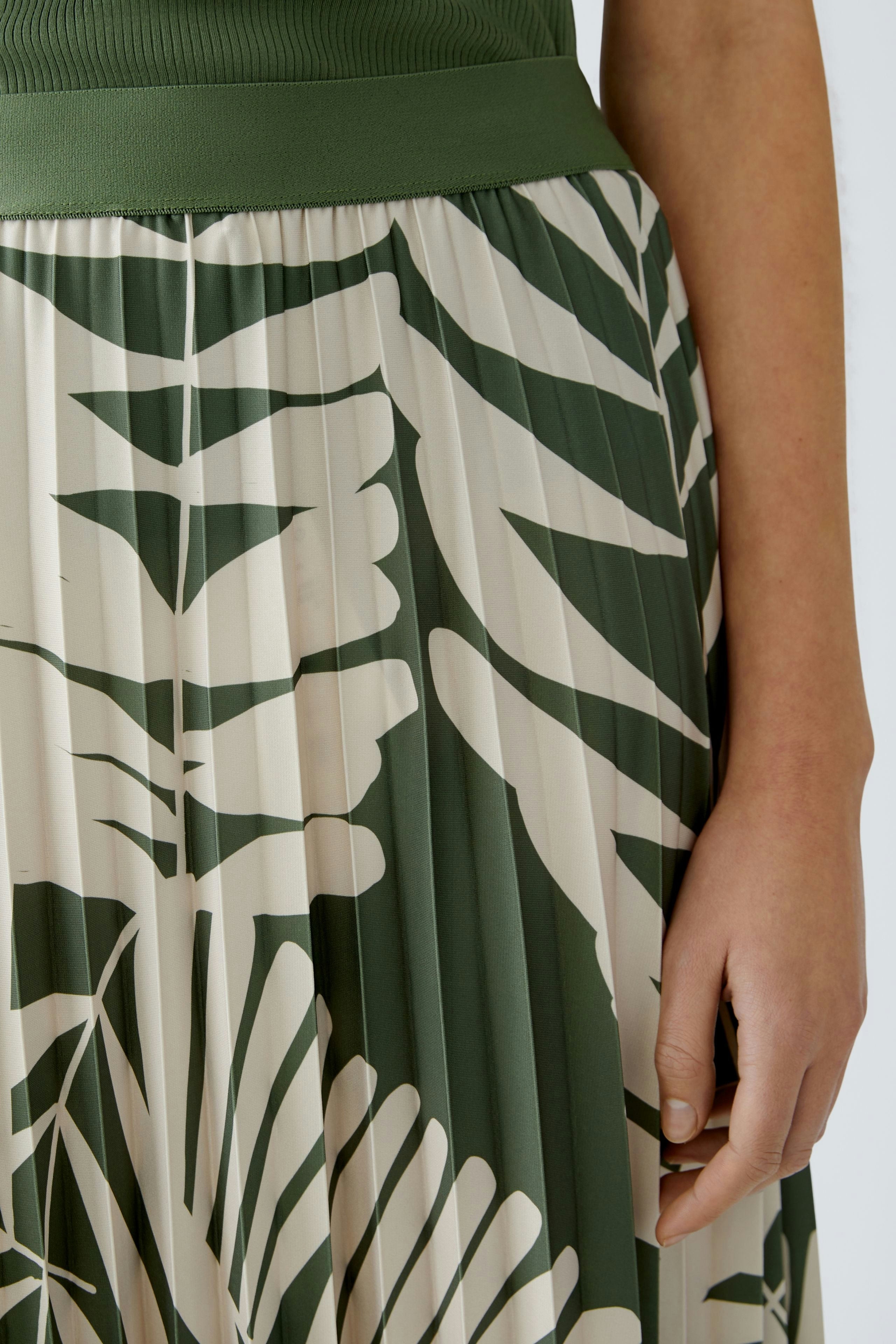 Eleganter Plisseerock: Detailaufnahme einer Frau in einem modischen, gemusterten Plisseerock.