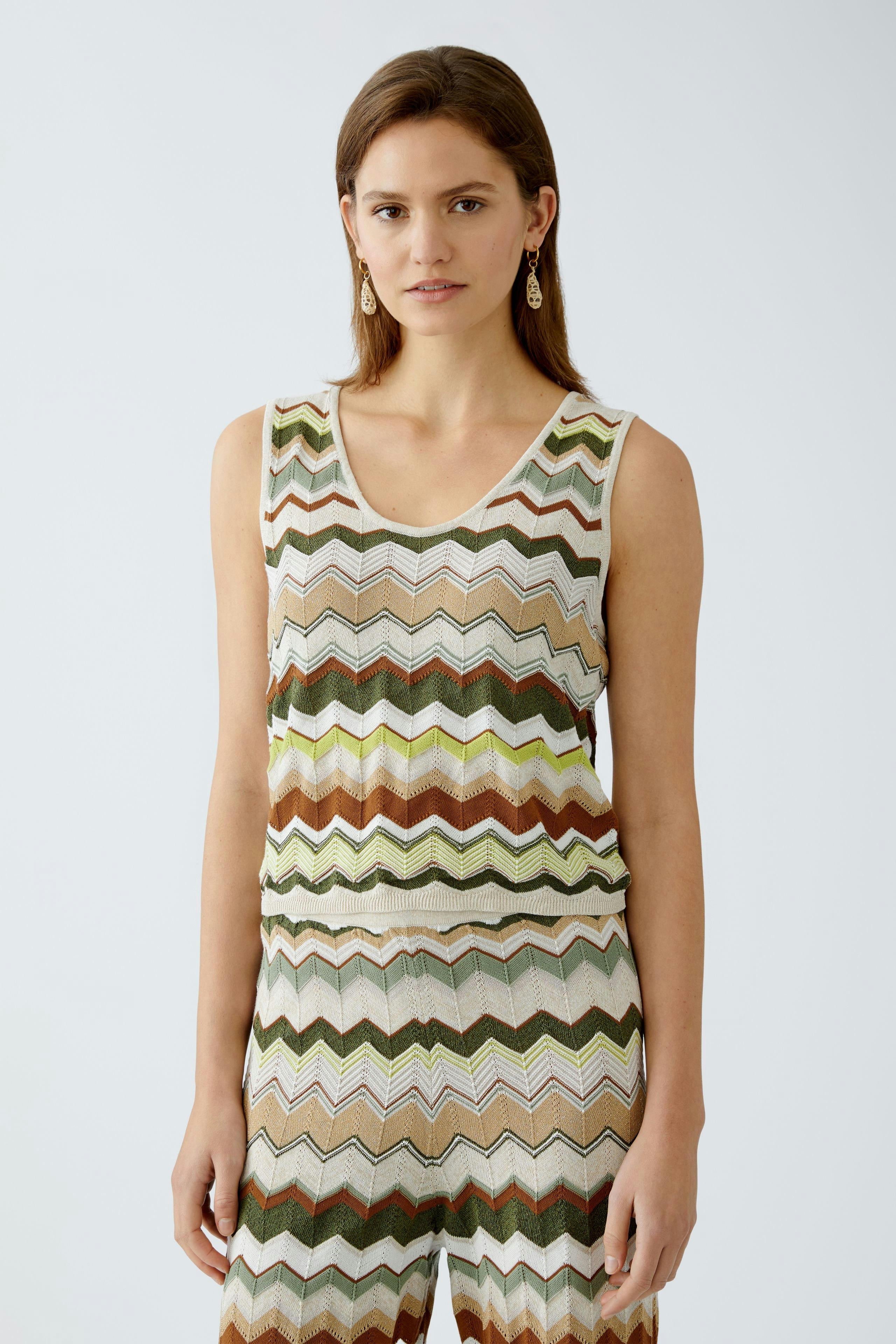 Stylisches Damen-Top: Frau trägt ein ärmelloses, gestreiftes Top in Erdtönen.