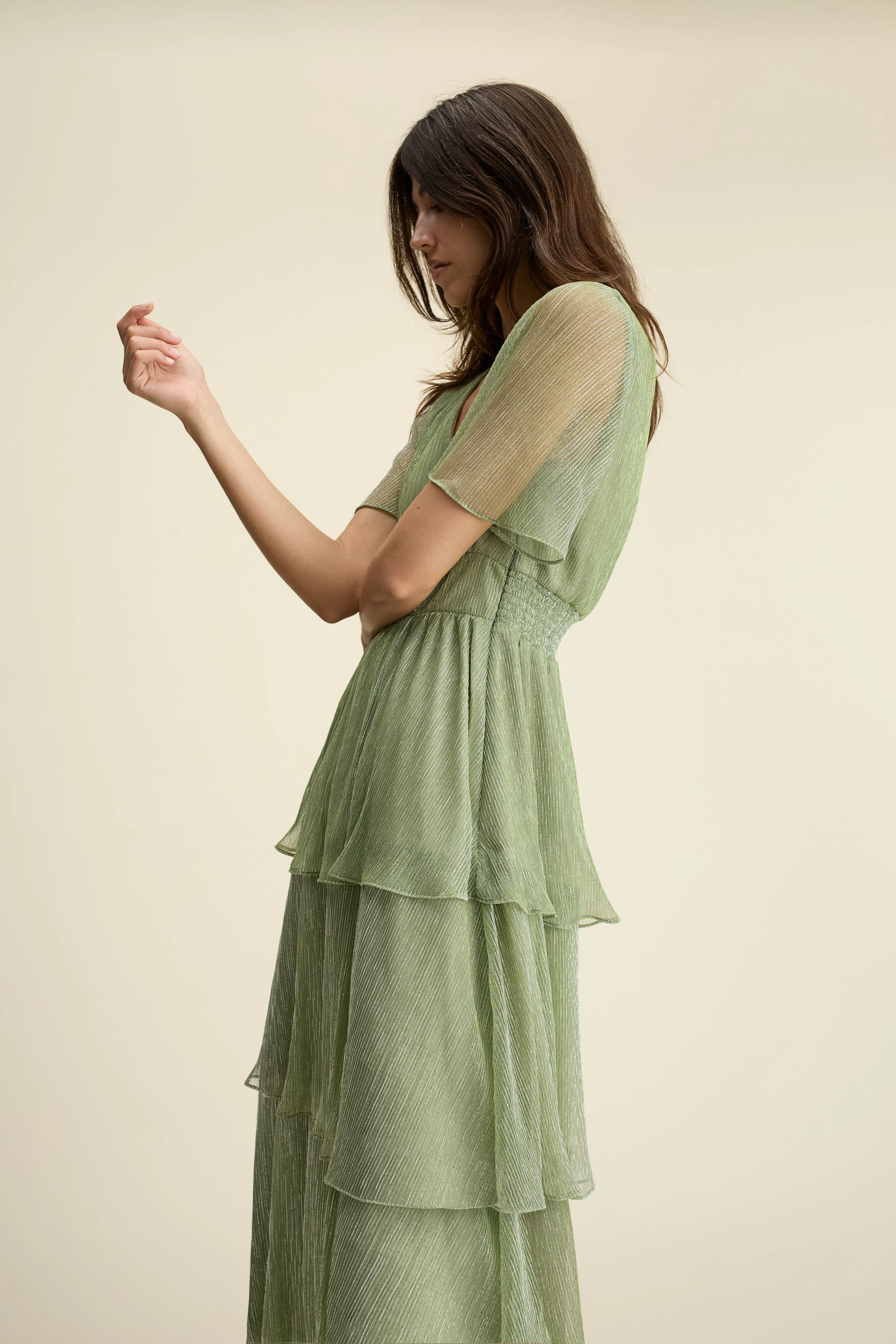 Light green maxi dress: Woman in a tiered design with short sleeves, showcasing a relaxed style.