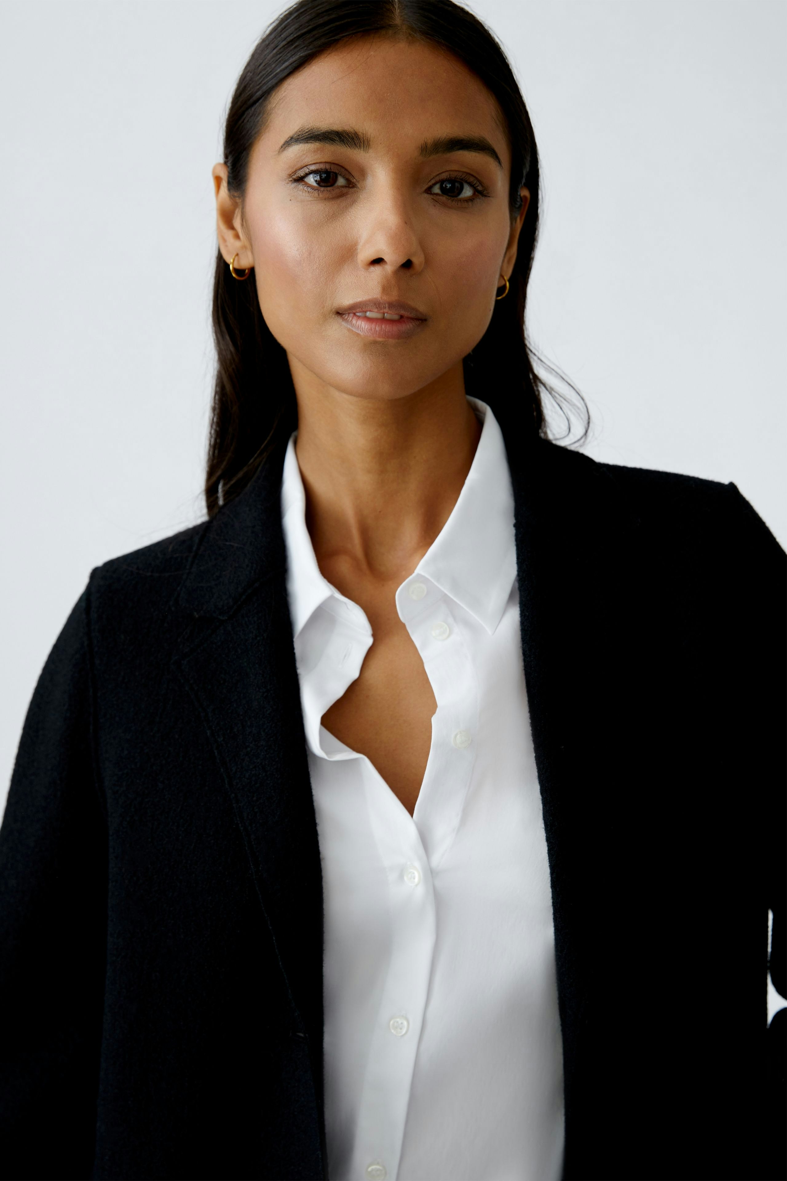 Eleganter Damen-Mantel: Frau in schwarzem, klassischem Mantel mit Knöpfen, stilvoll und modern.