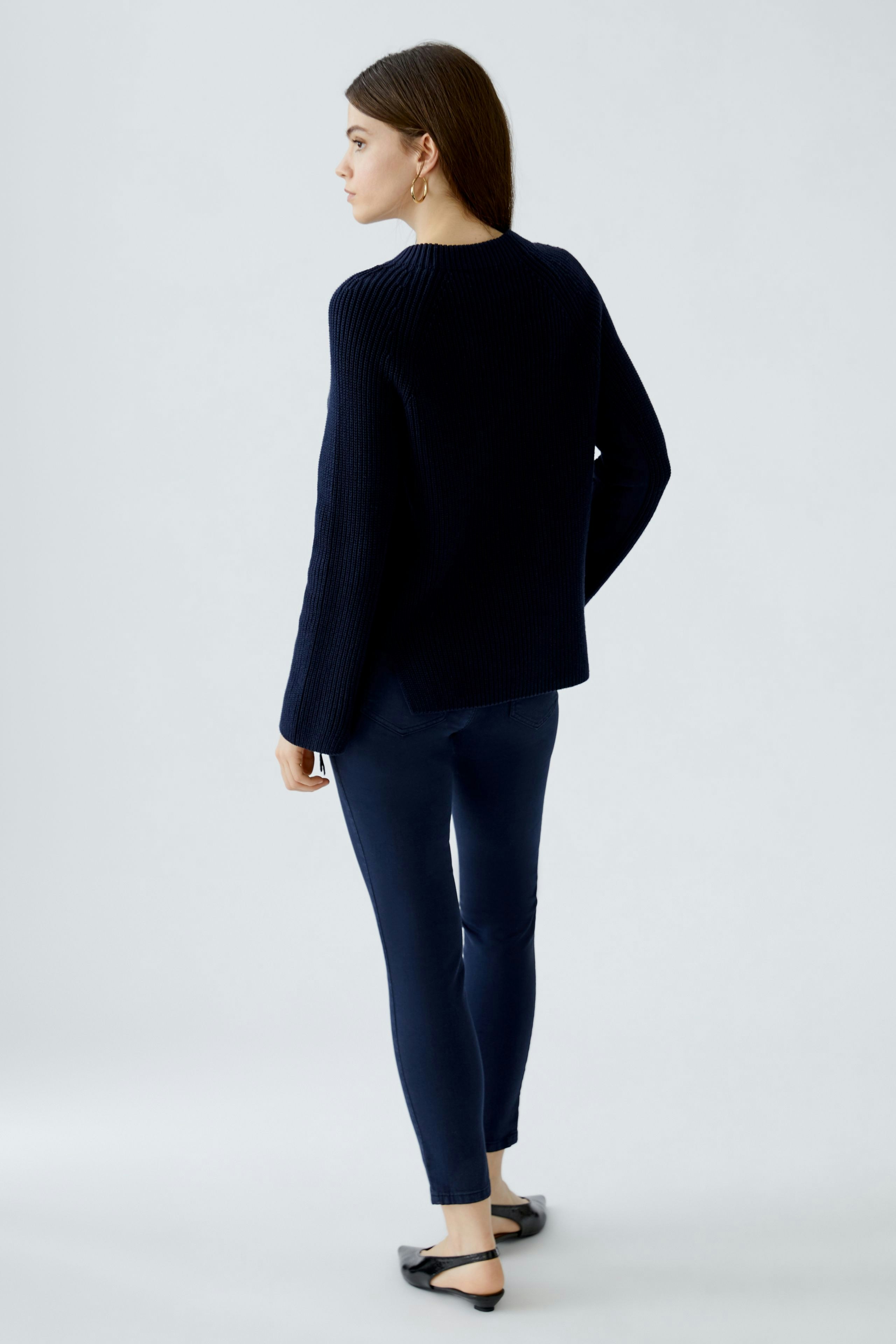 Damen-Pullover: Frau in einem dunkelblauen, lässigen Strickpullover mit weitem Schnitt.