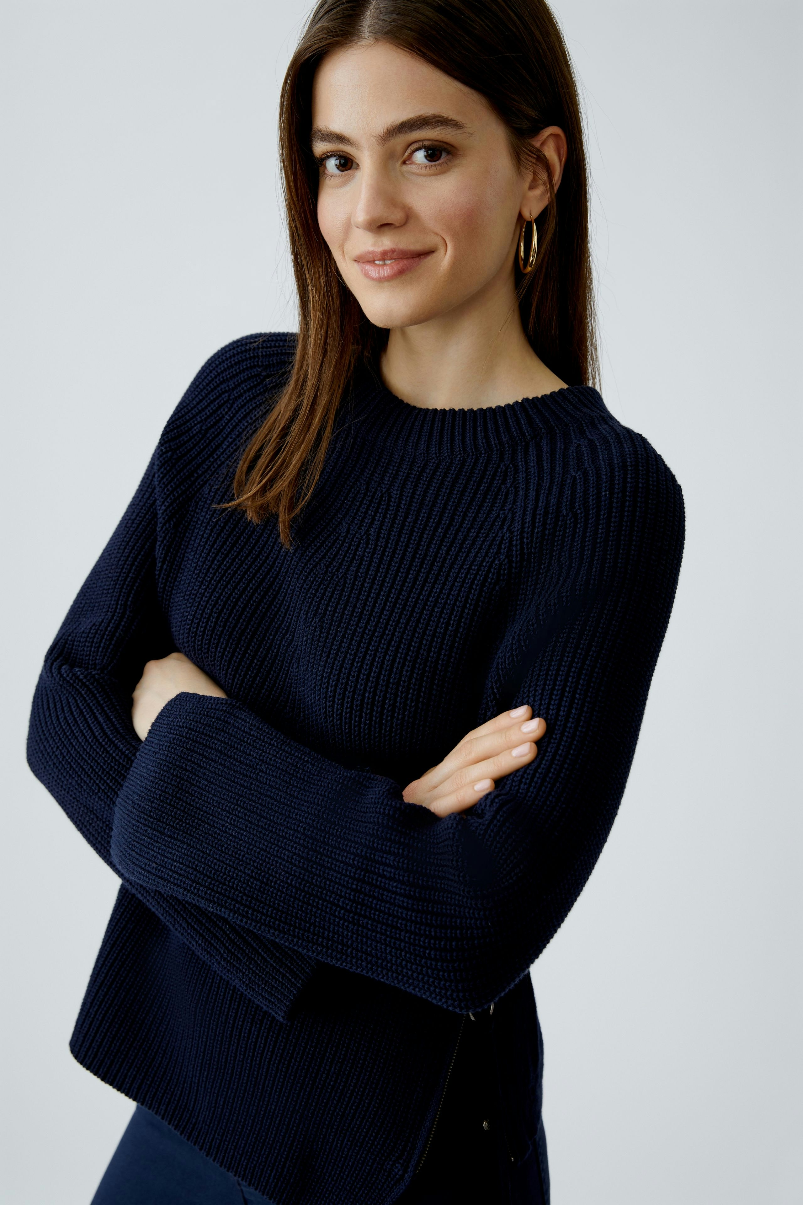 Damen-Pullover: Frau in dunkelblauem, strukturiertem Pullover mit lässigem Schnitt und weitem Arm.