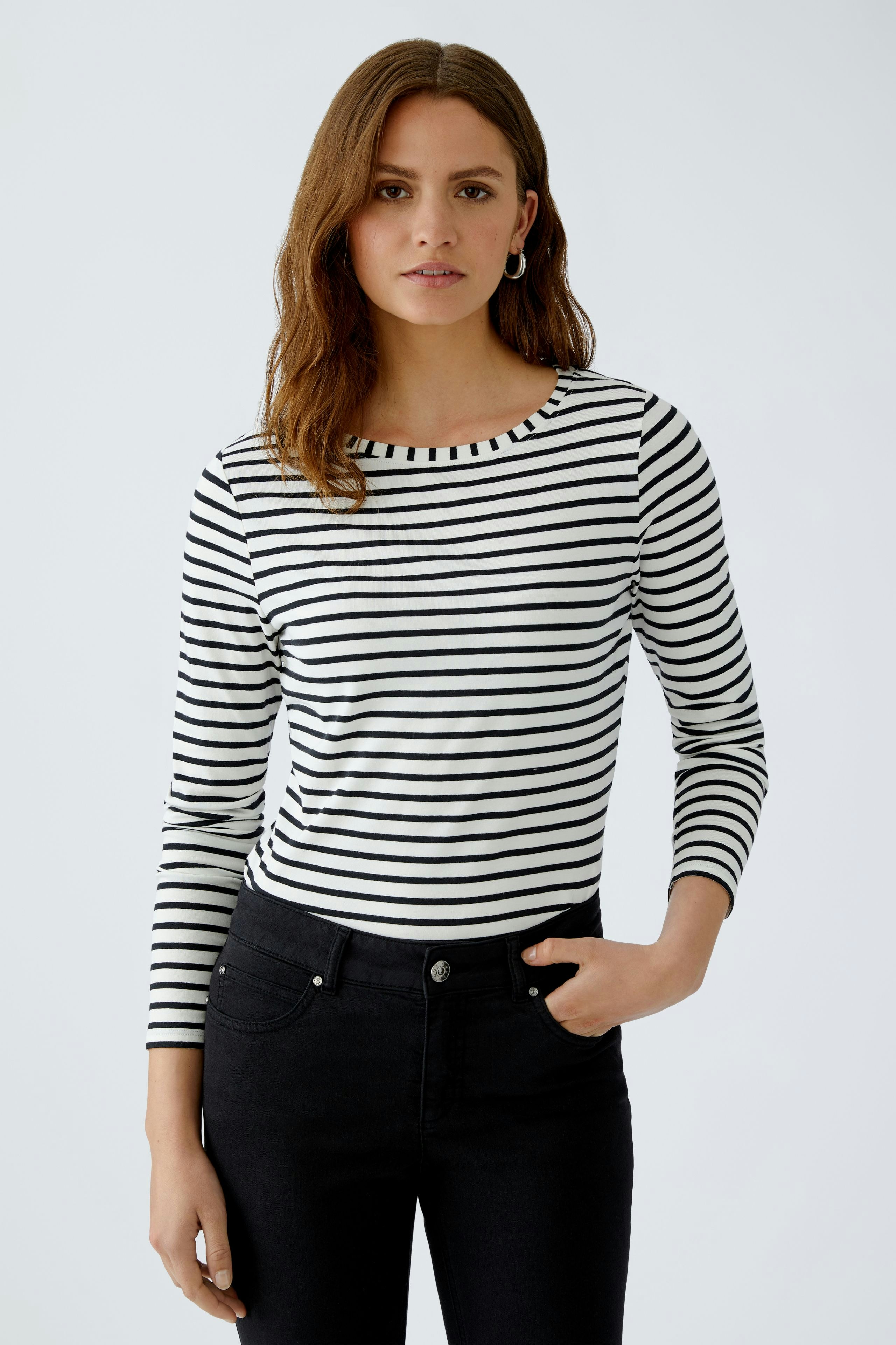 Damen Langarmshirt: Junge Frau in gestreiftem Shirt mit Rundhalsausschnitt und lässiger Ausstrahlung.