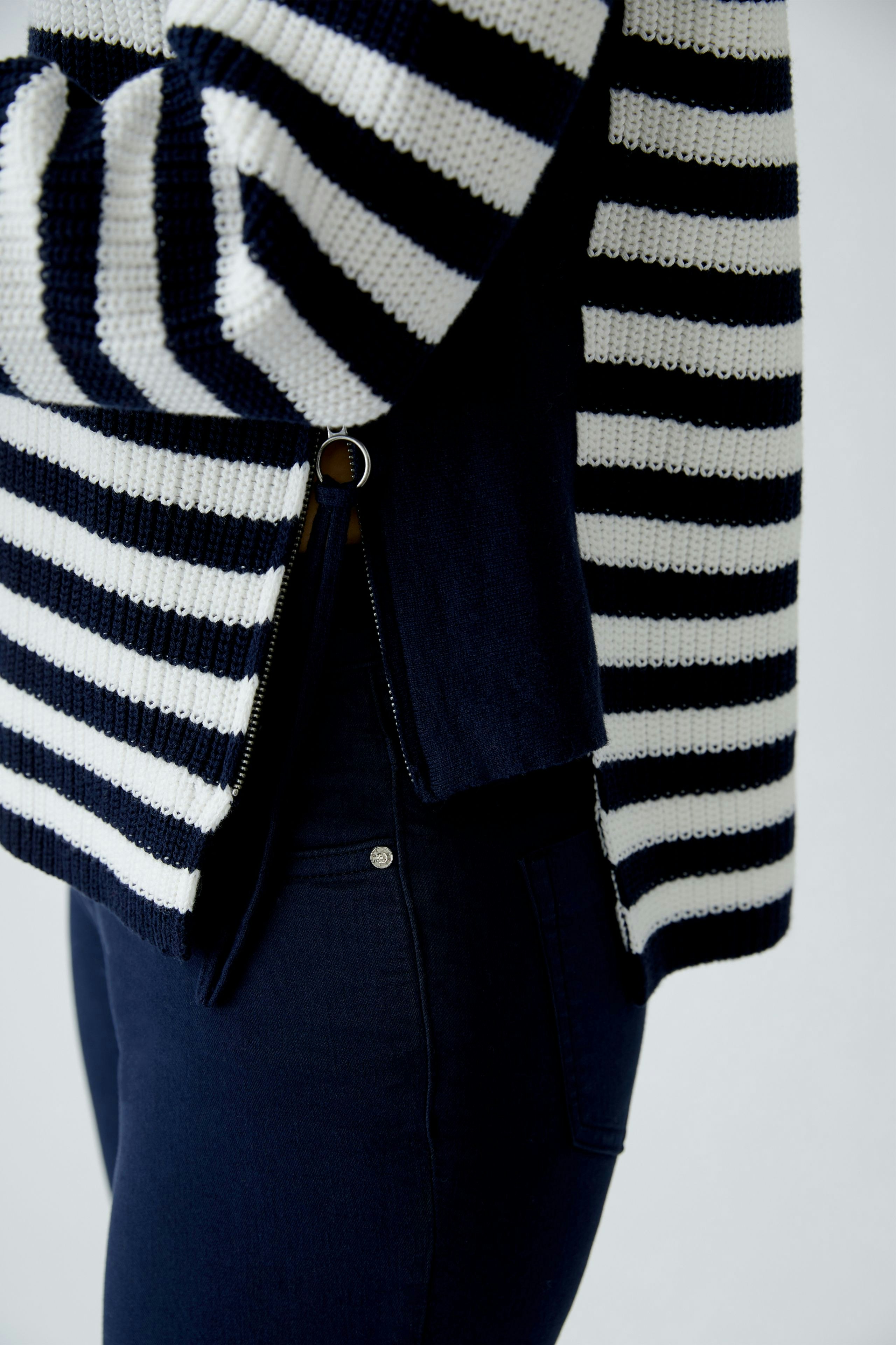 Damen-Pullover: Junge Frau im gestreiften Pullover in Blau und Weiß mit lässigem Schnitt.