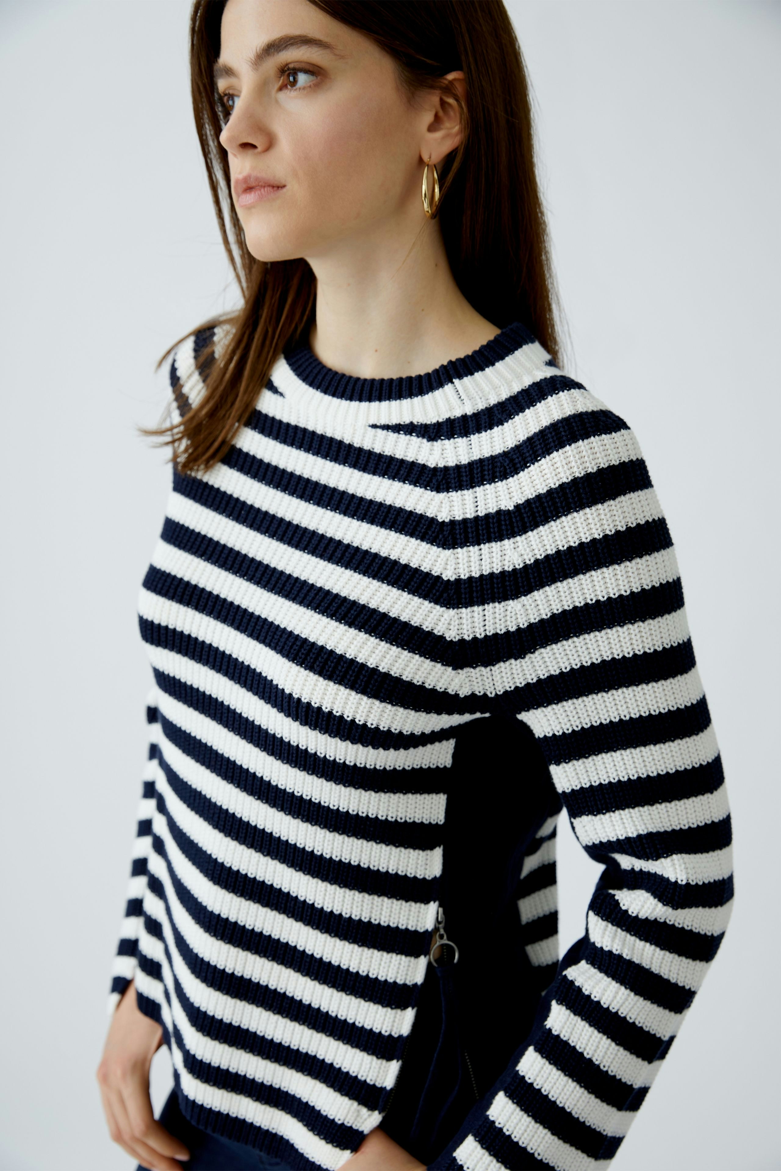 Damen-Pullover: Frau in gestreiftem Pullover mit breiten Streifen in Blau und Weiß, lässiger Look.