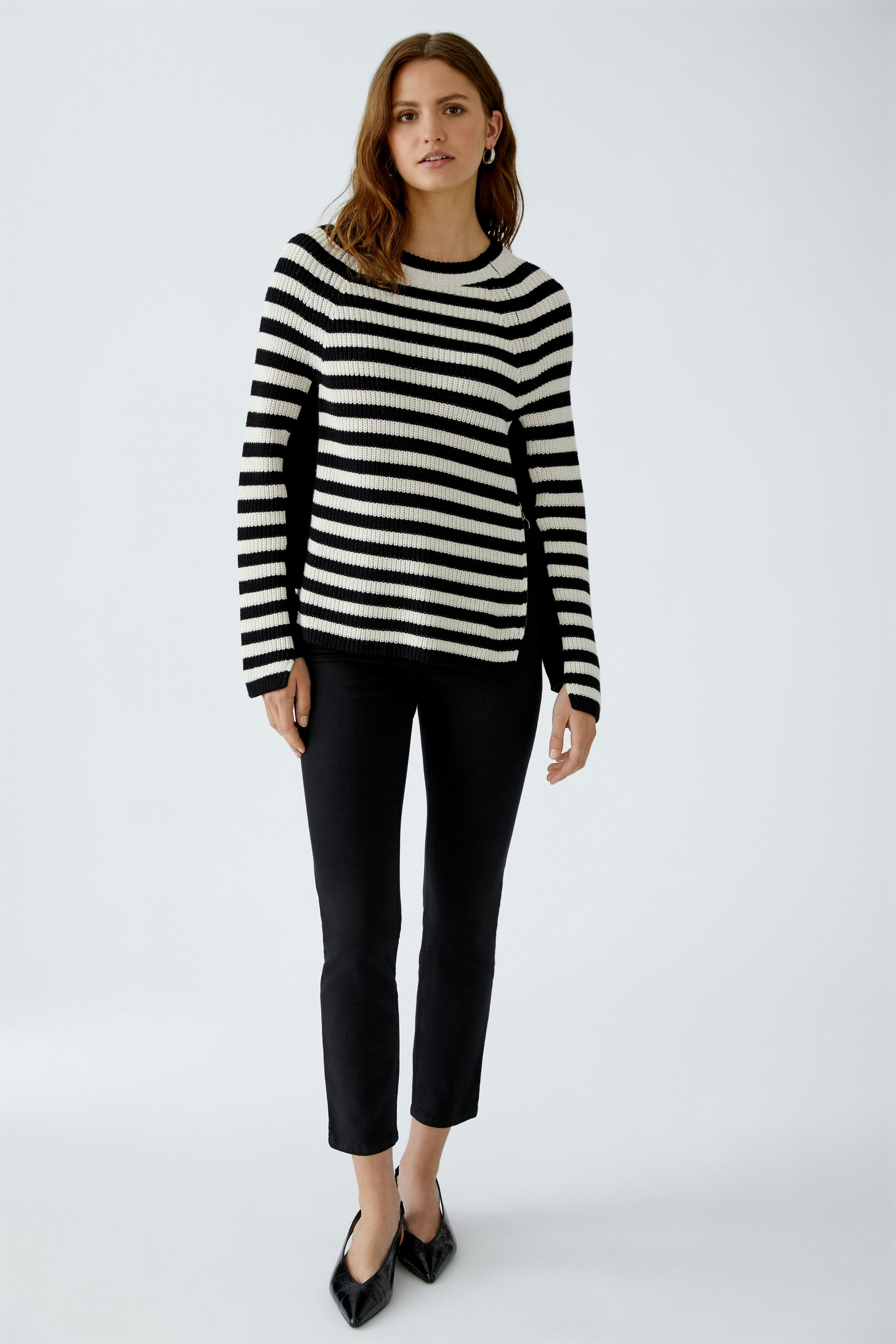 Stylish women's pullover: A woman in a black and white striped pullover paired with black pants.