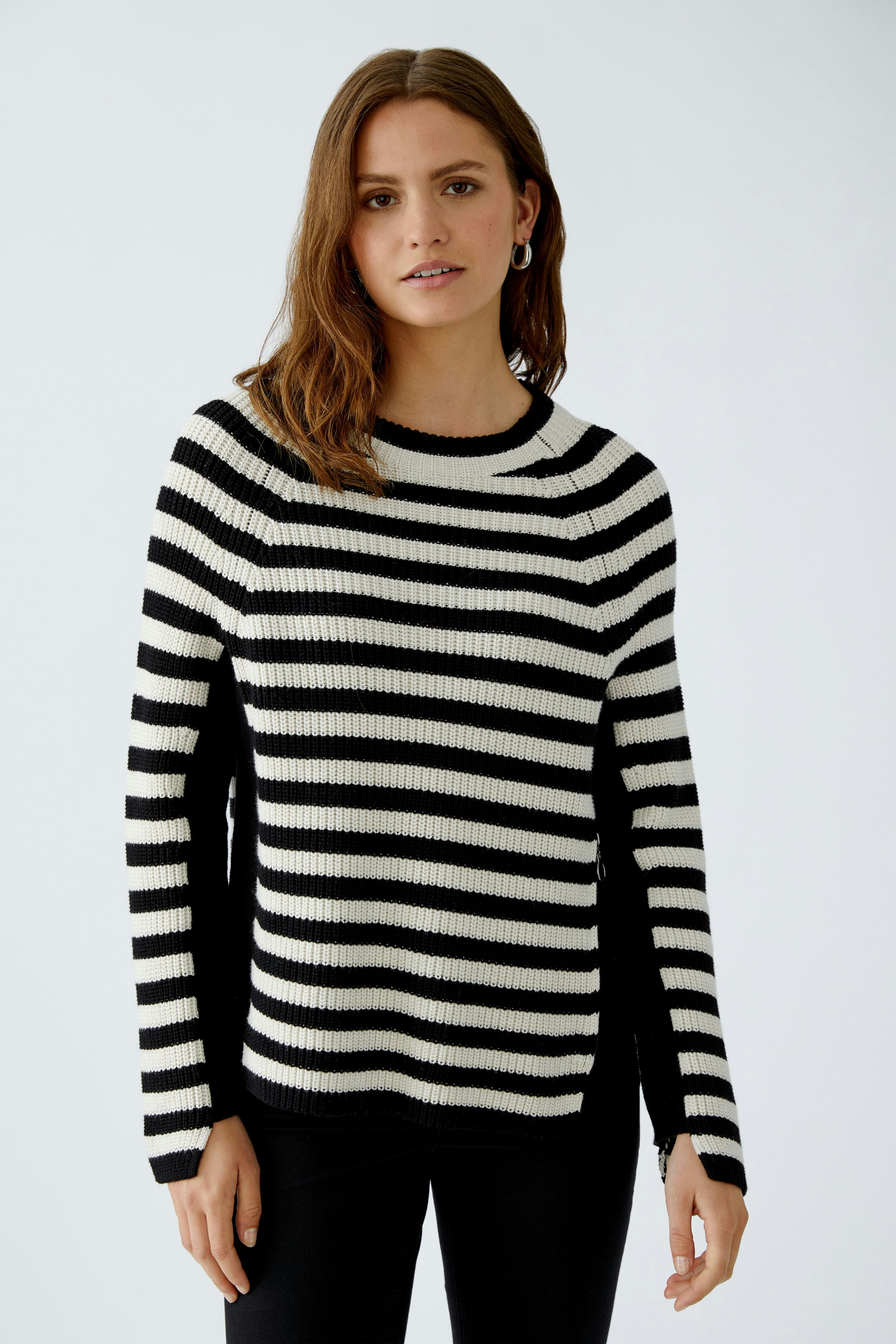 Stylish women's pullover: A woman in a black and white striped pullover with flared sleeves.