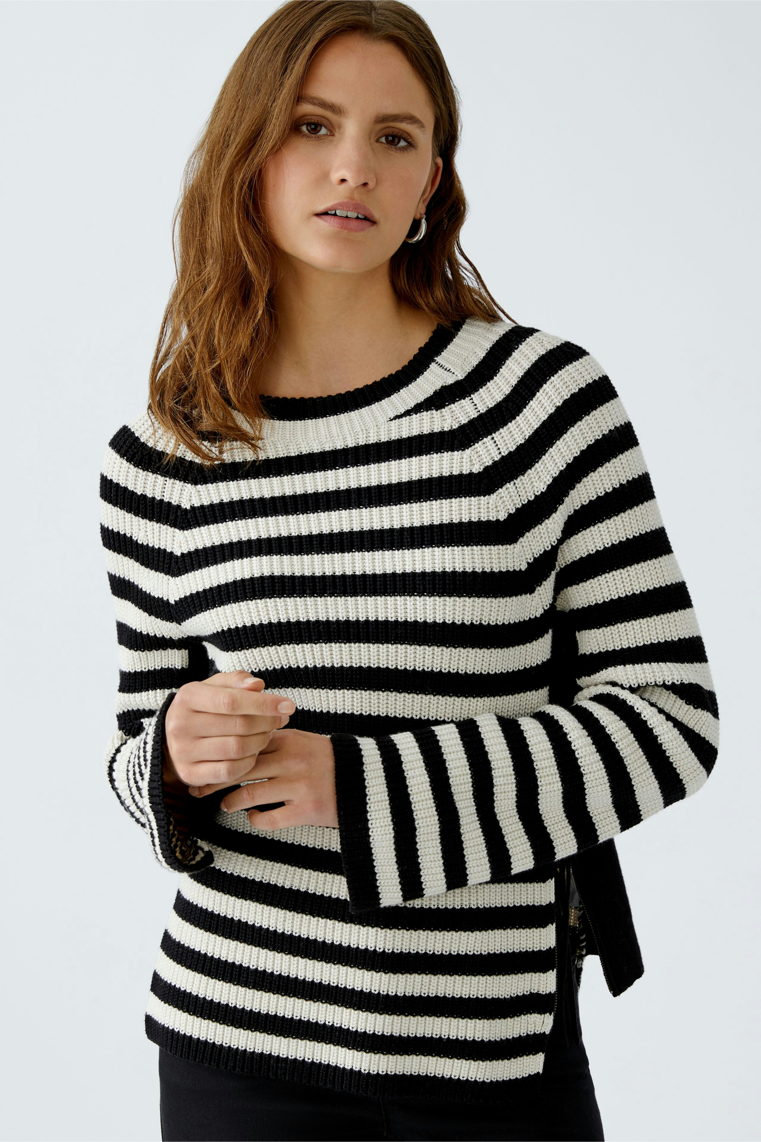 Stylish women's pullover: Black and white striped design with a modern zip detail.