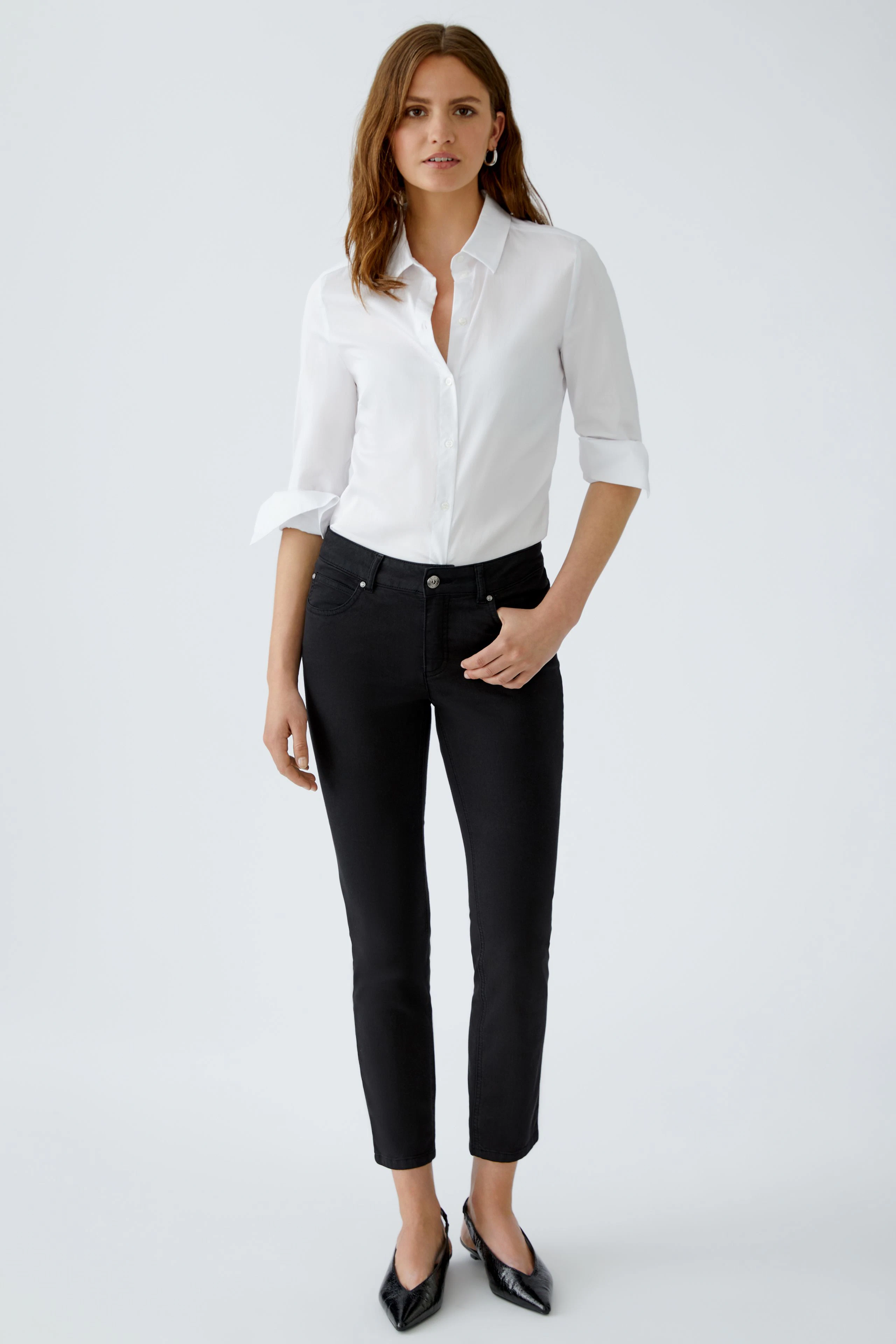 Elegante Damen-Bluse: Frau in weißer Bluse mit Knopfleiste und lässigem Look.