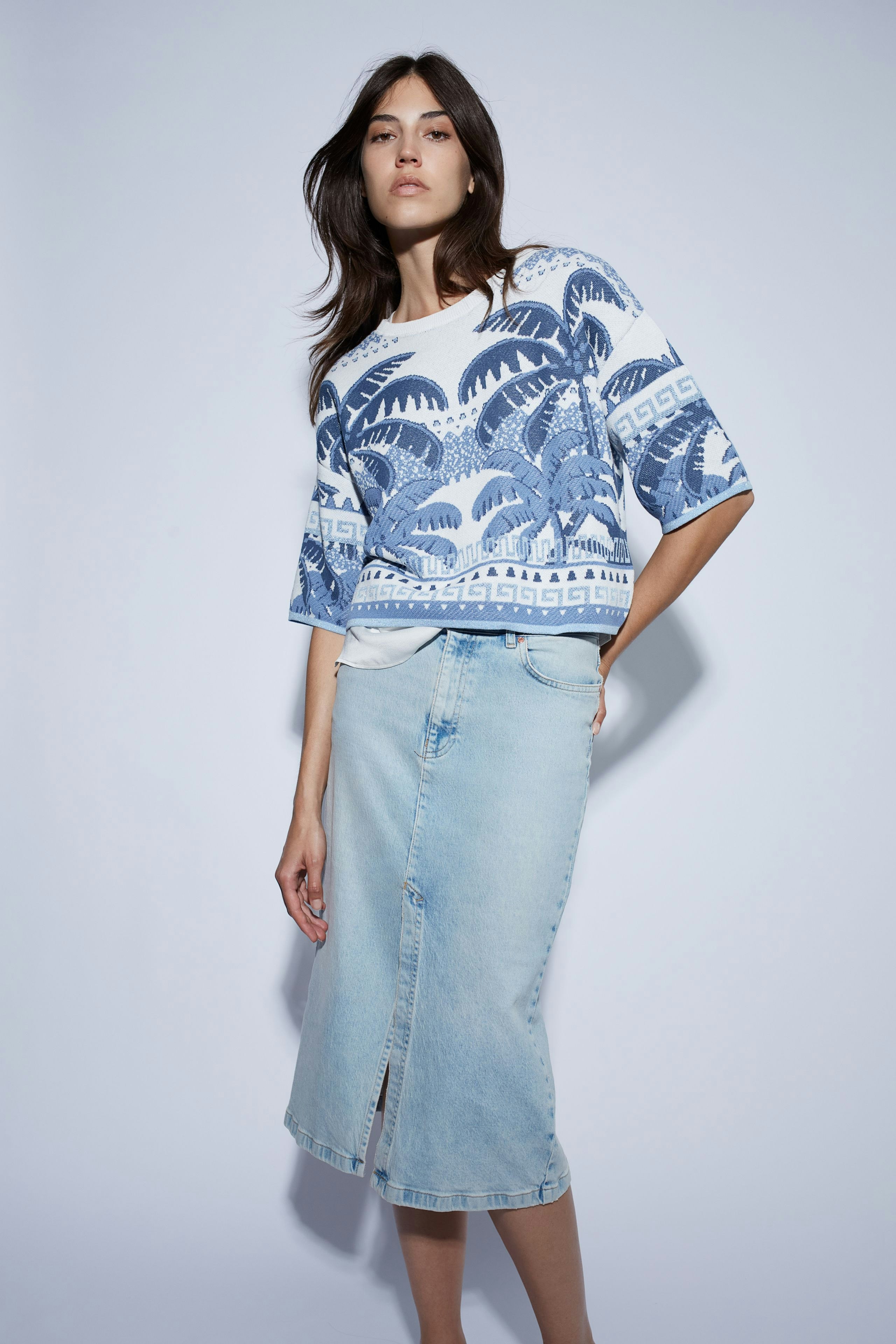 Stylish women's top: A woman in a colorful patterned cardigan paired with light jeans, exuding casual elegance.