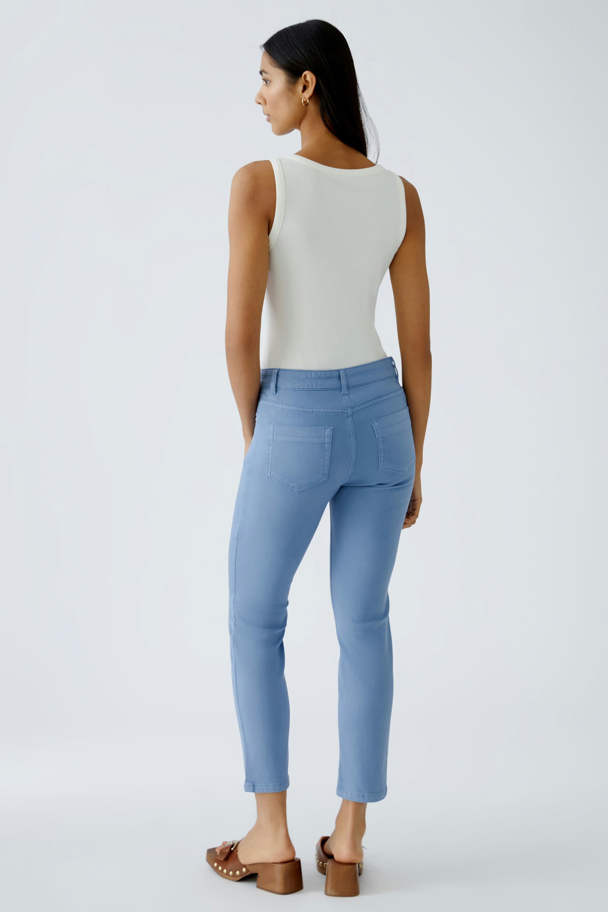 Stylish jeggings: Woman in light blue jeggings, paired with a simple white top, showcasing a modern fit.