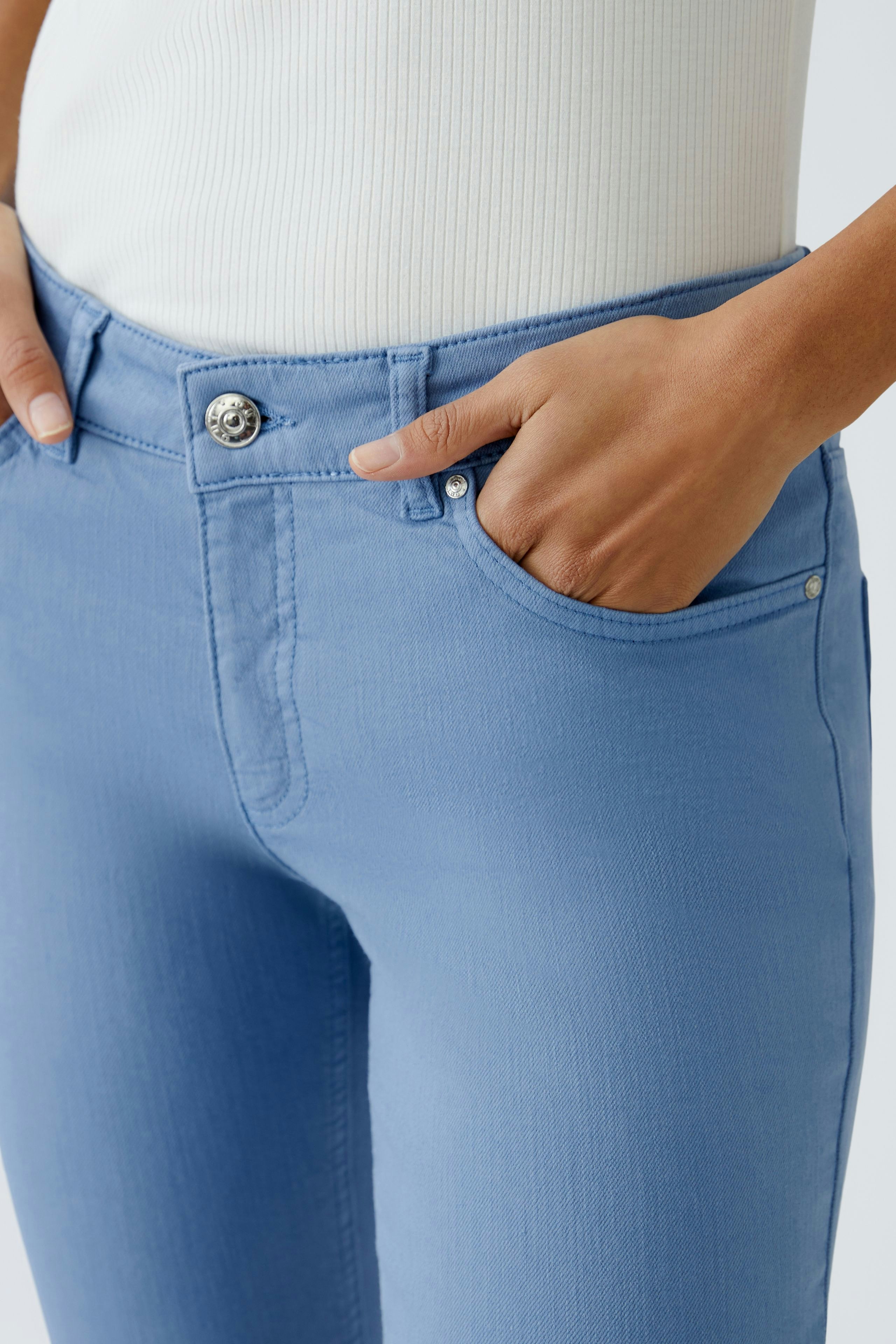 Stylish jeggings for women: Close-up of a woman wearing light blue jeggings with pockets.