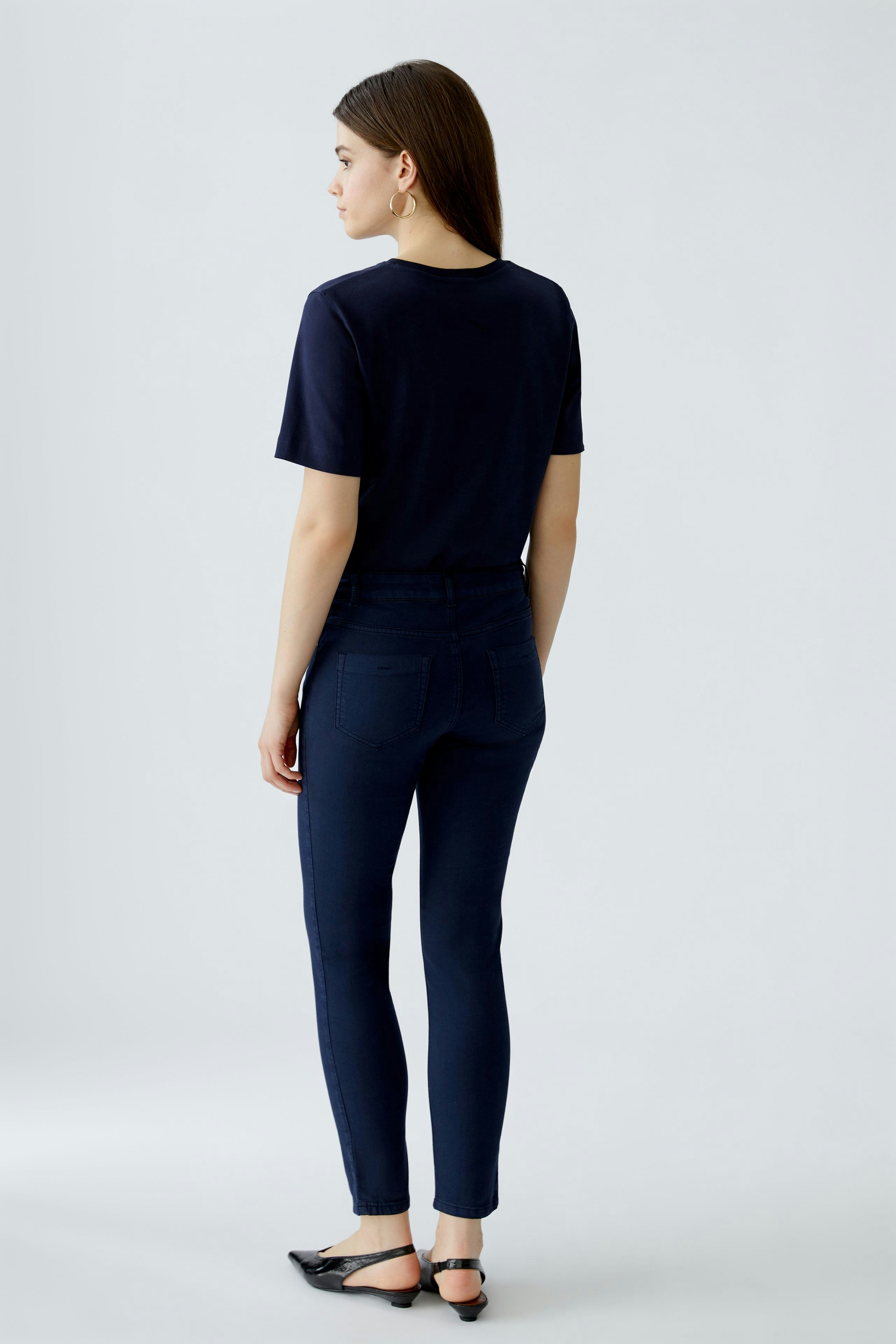 Stylish jeggings: Woman in fitted navy jeggings, showcasing a sleek silhouette and modern design.