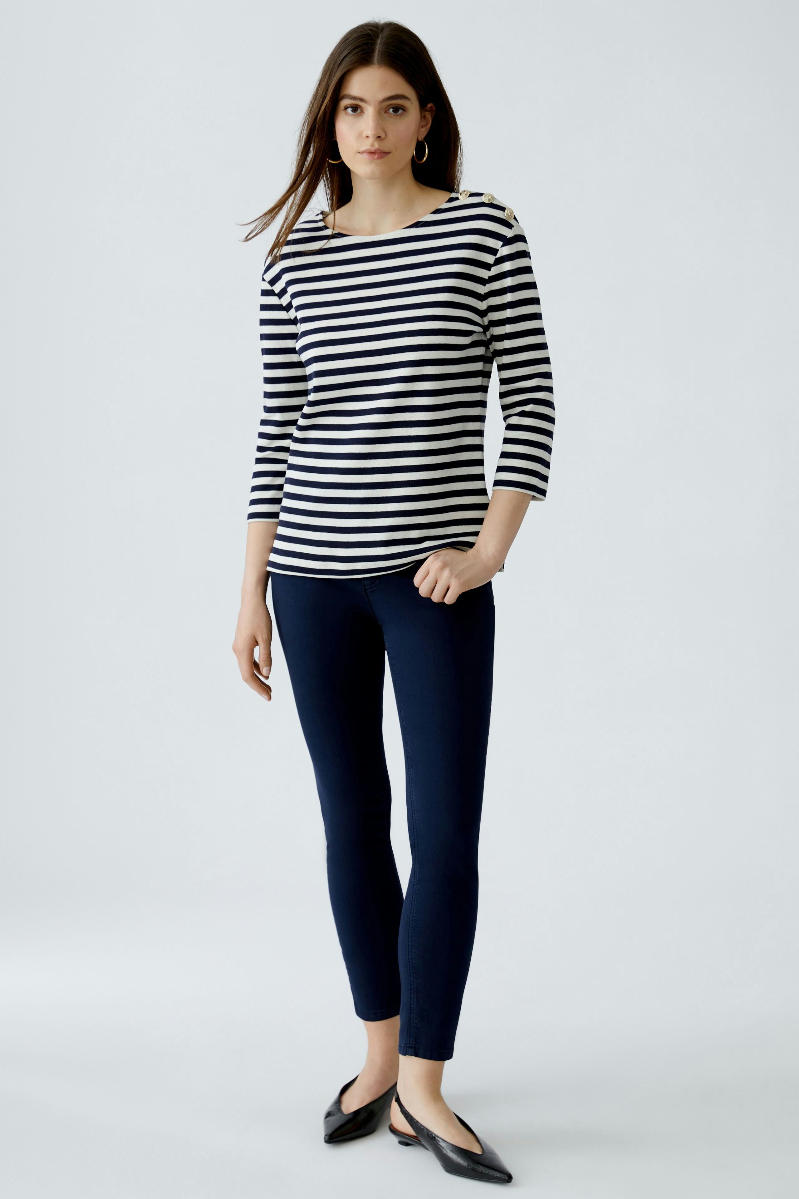 Stylish women's long-sleeve shirt: A woman in a striped pullover pairs it with wide-leg jeans.