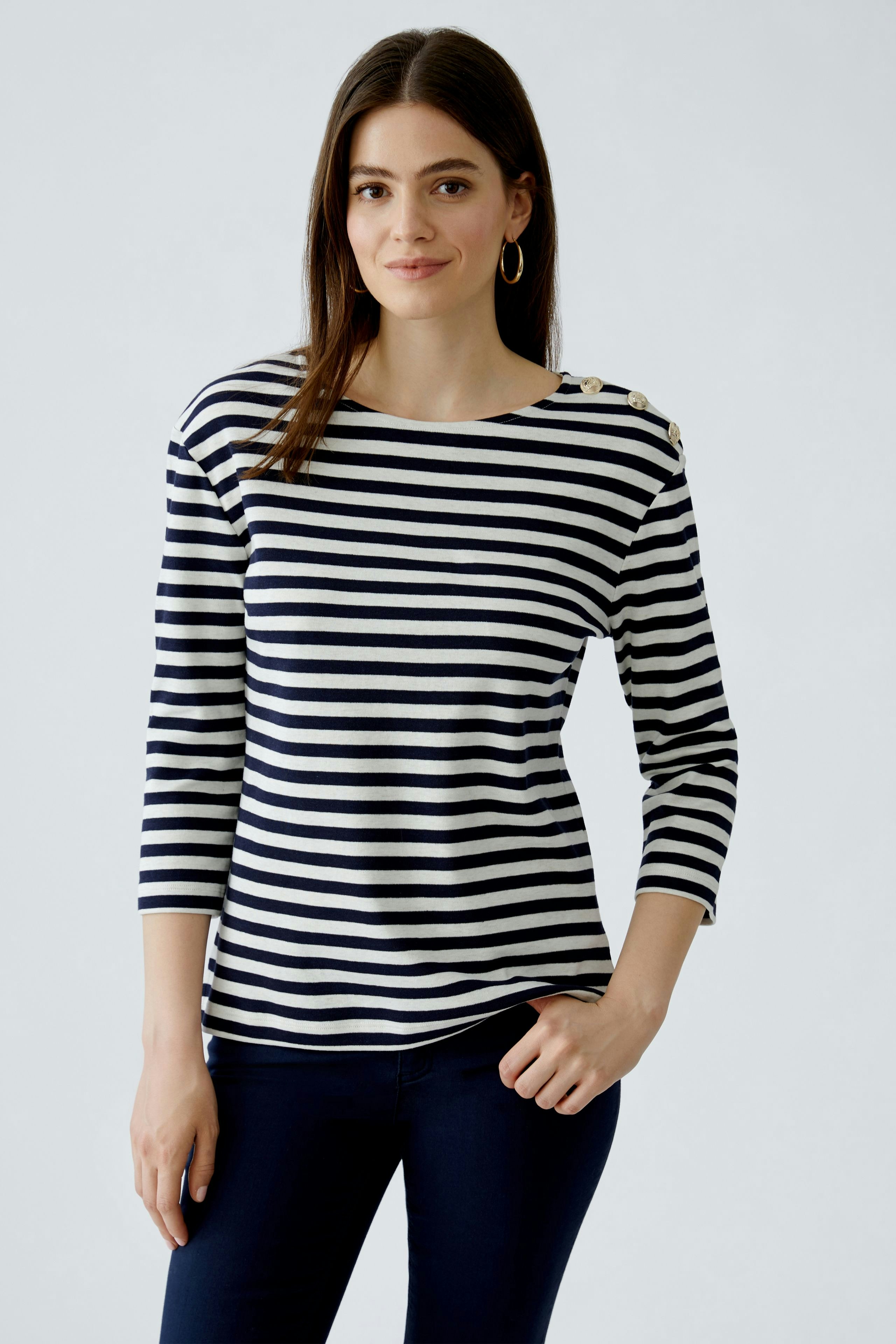 Stylish long-sleeve shirt: Woman in a navy and white striped pullover, exuding casual elegance.