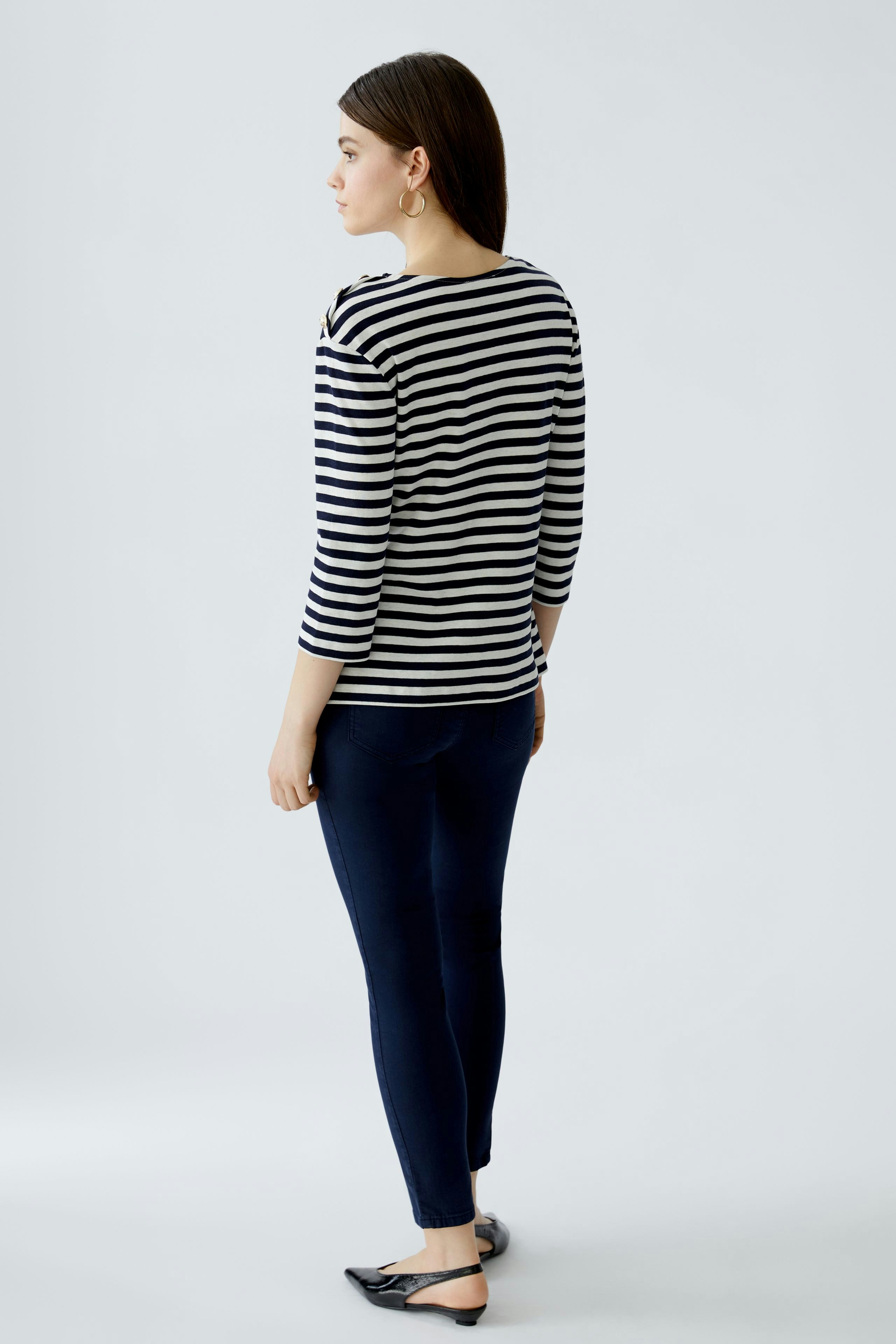 Stylish women's long-sleeve shirt: A woman in a striped pullover, paired with wide-leg jeans.