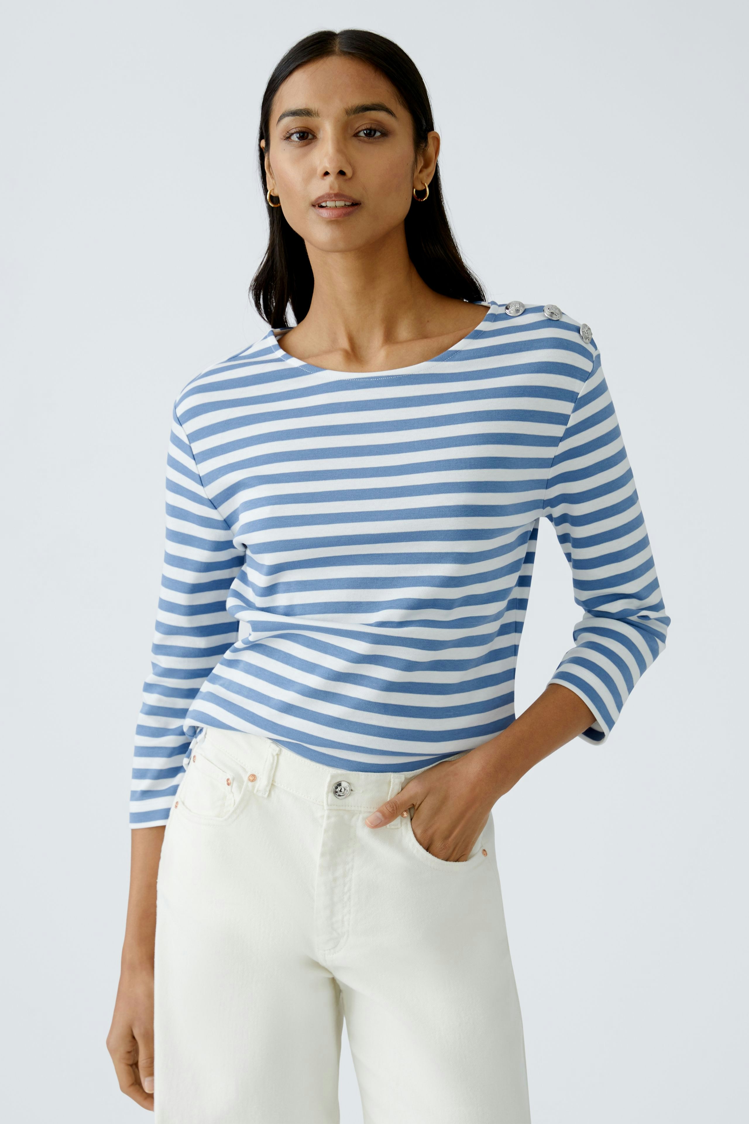 Stylish long-sleeve shirt: Woman in a blue and white striped pullover with button details.