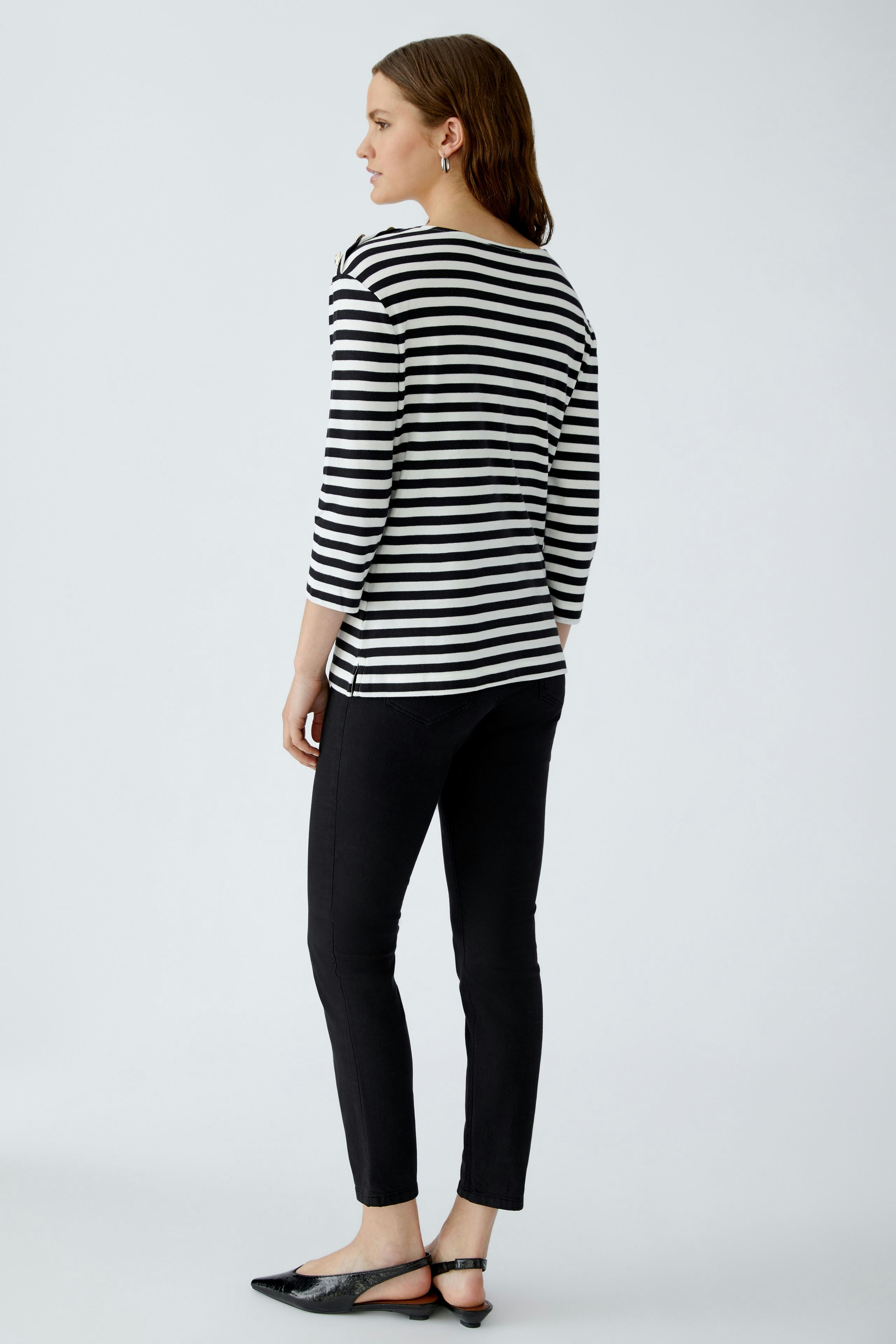 Stylish women's long-sleeve shirt: A woman in a striped pullover with a relaxed fit.