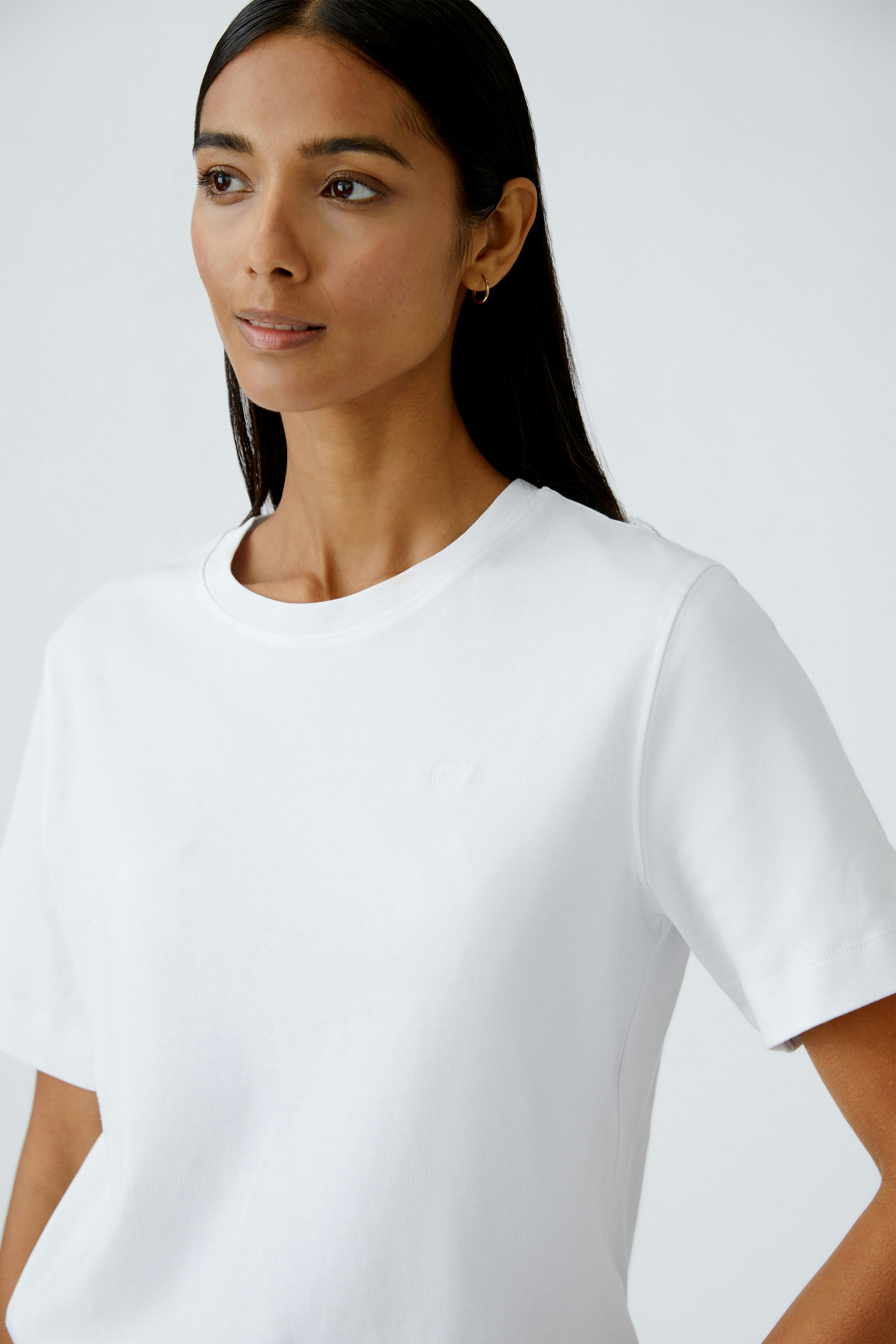 Casual women's T-shirt: Young woman in a white tee with a relaxed fit and short sleeves.