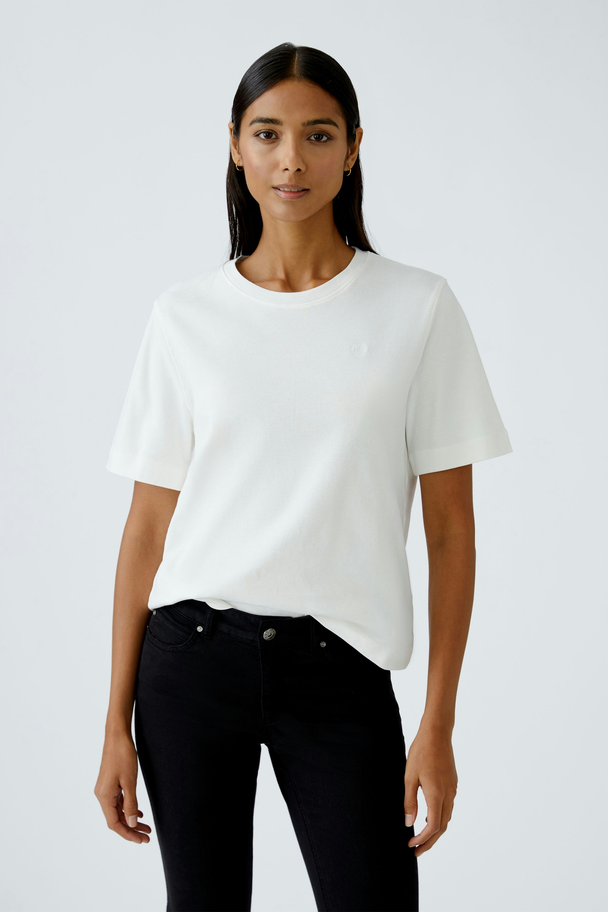 Casual women's T-shirt: A woman in a white tee with short sleeves and a relaxed fit.