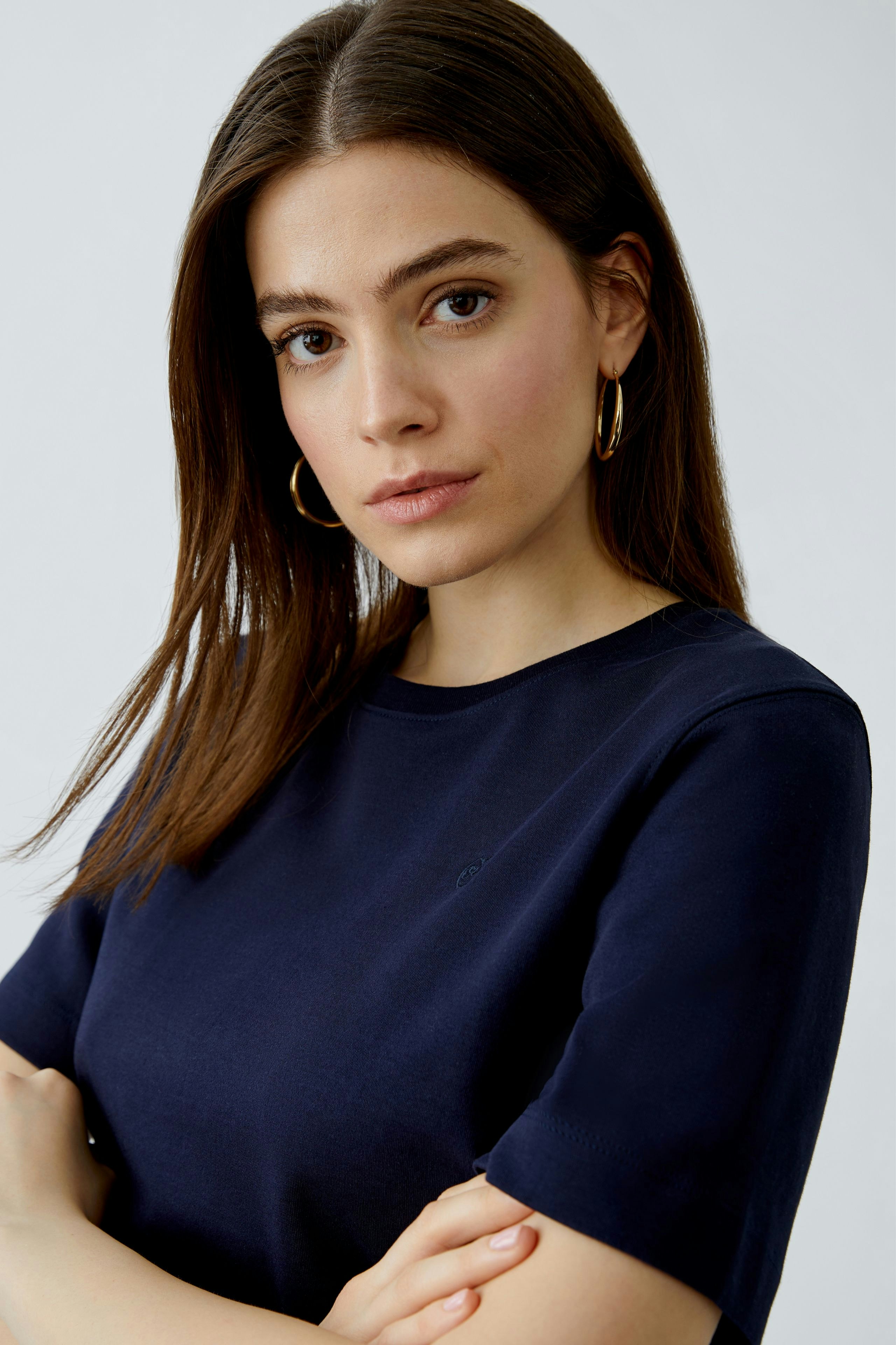 Damen-T-Shirt: Junge Frau in einem navyblauen T-Shirt mit kurzen Ärmeln und lässigem Look.