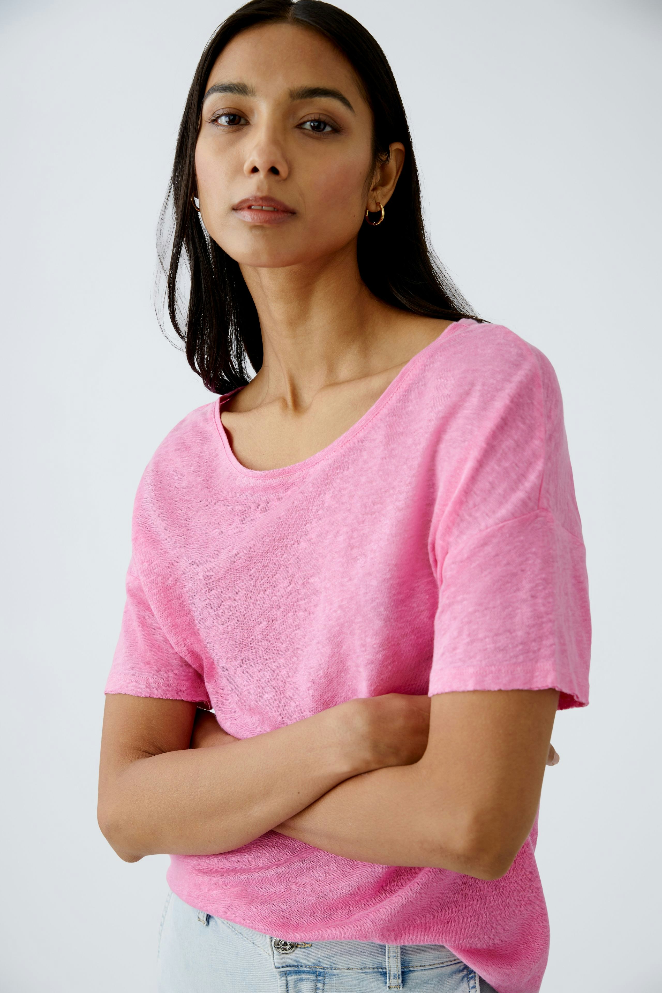 Damen-T-Shirt in leuchtendem Pink: Frau mit lässigem Look, die selbstbewusst in die Kamera blickt.