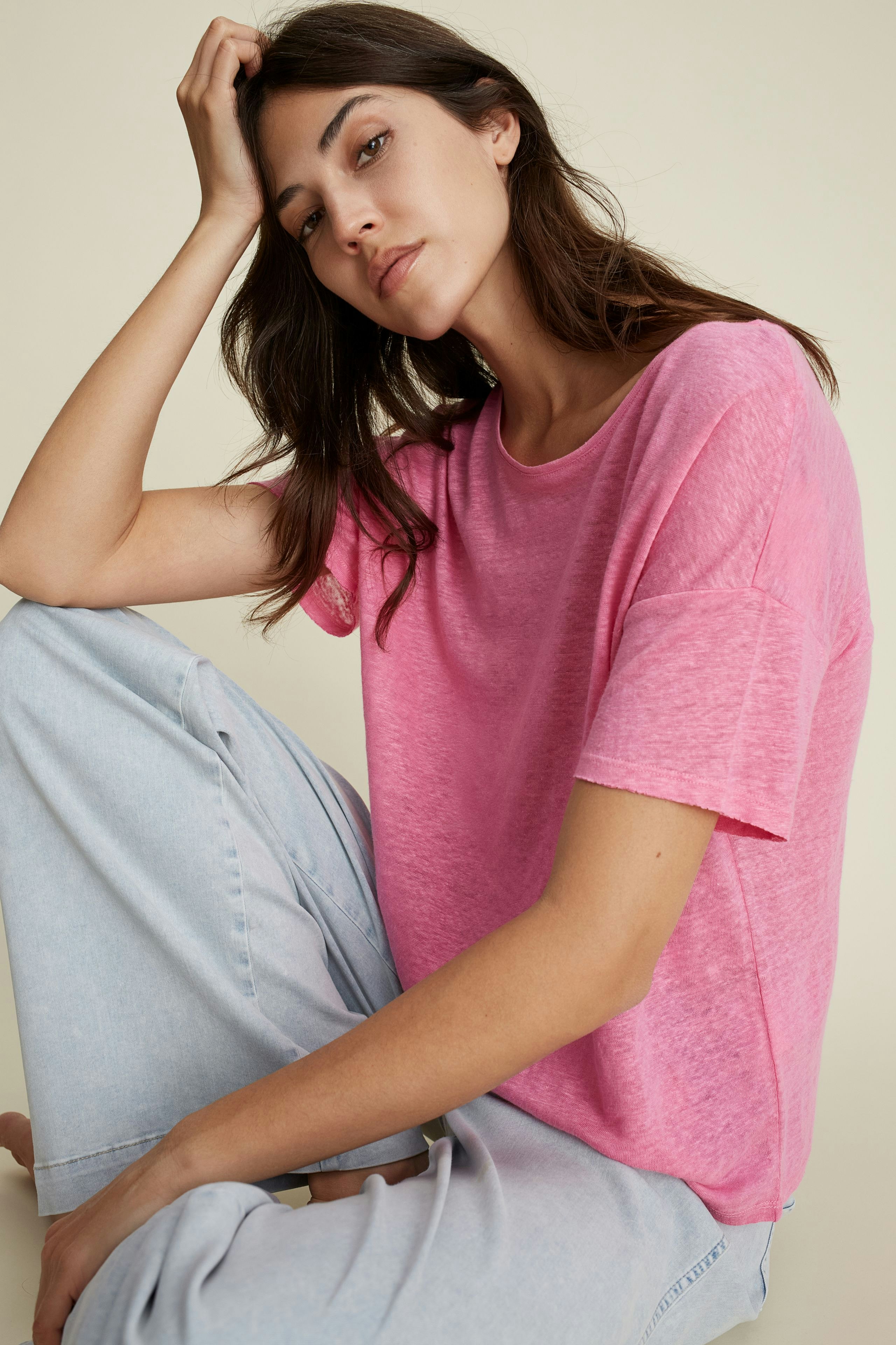 Leichtes Damen-T-Shirt in Pink: Frau sitzt entspannt und trägt ein lässiges, lockeres Shirt.