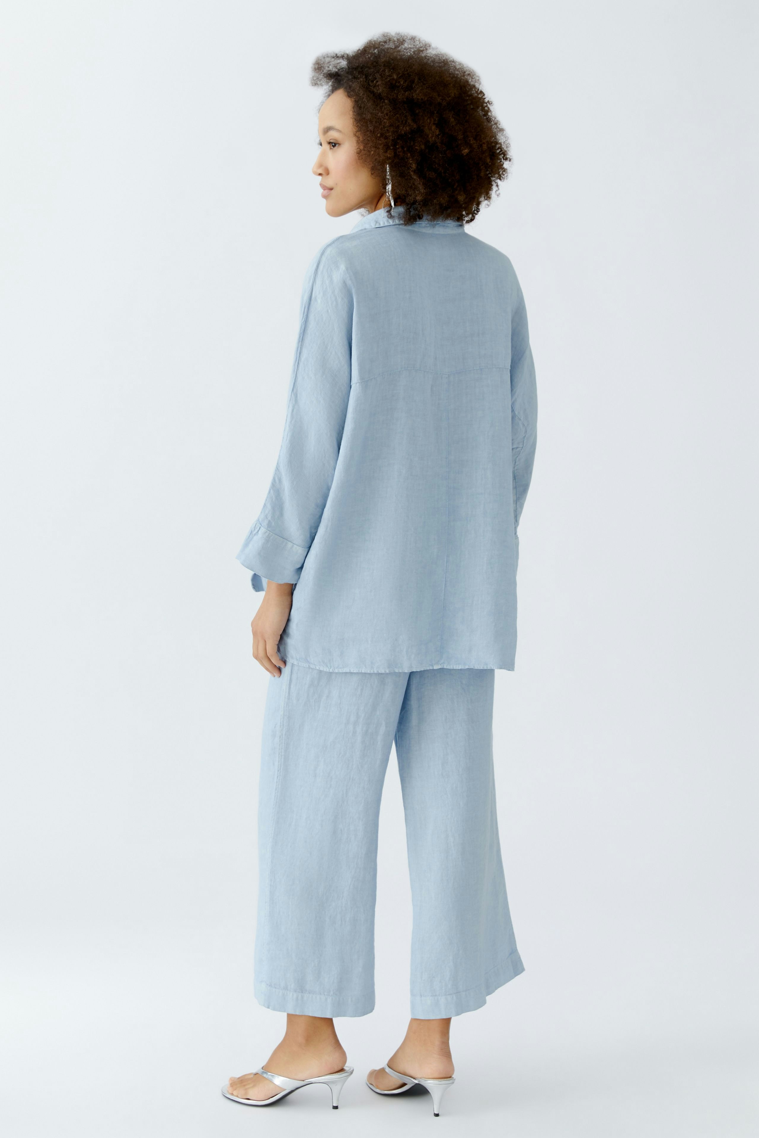 Casual women's blouse: A woman in a light blue blouse and matching pants, showcasing a relaxed style.