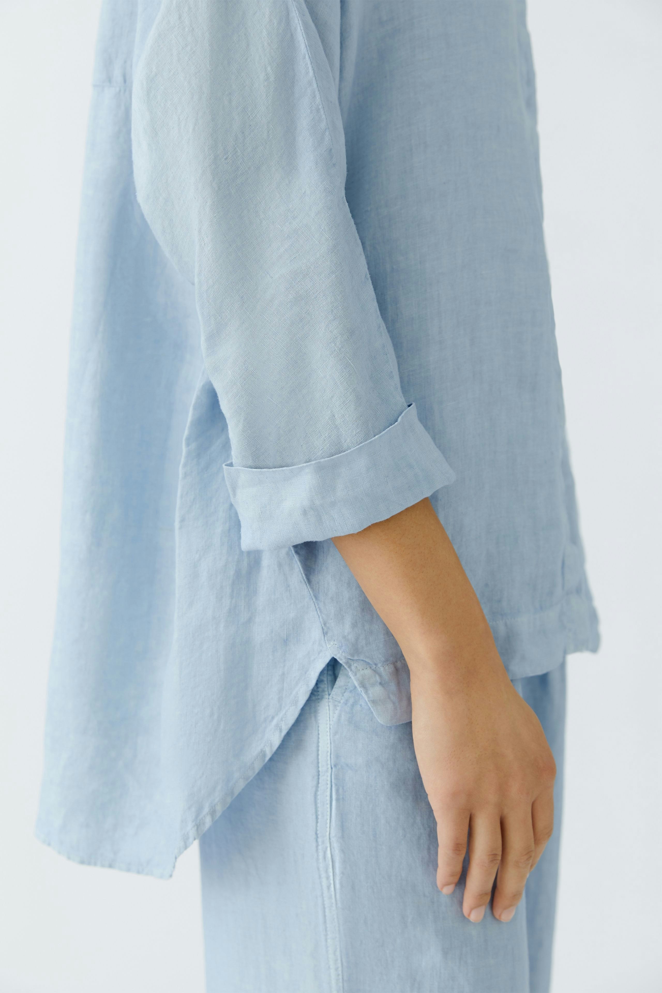 Light blue blouse: Woman in a relaxed fit, long-sleeve top with rolled cuffs, perfect for casual wear.