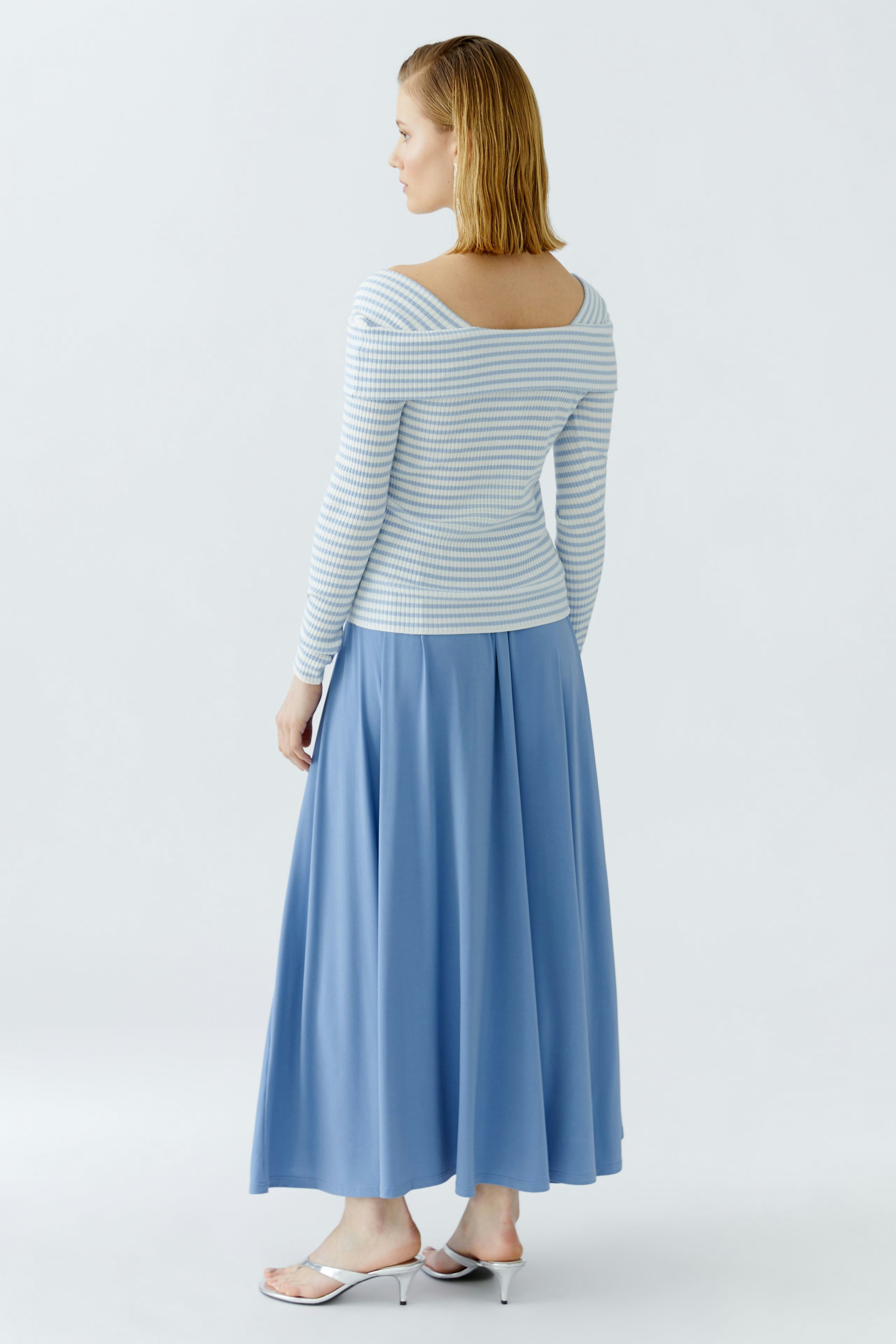 Casual women's pullover: Young woman in a striped pullover with a relaxed fit, paired with a flowing skirt.