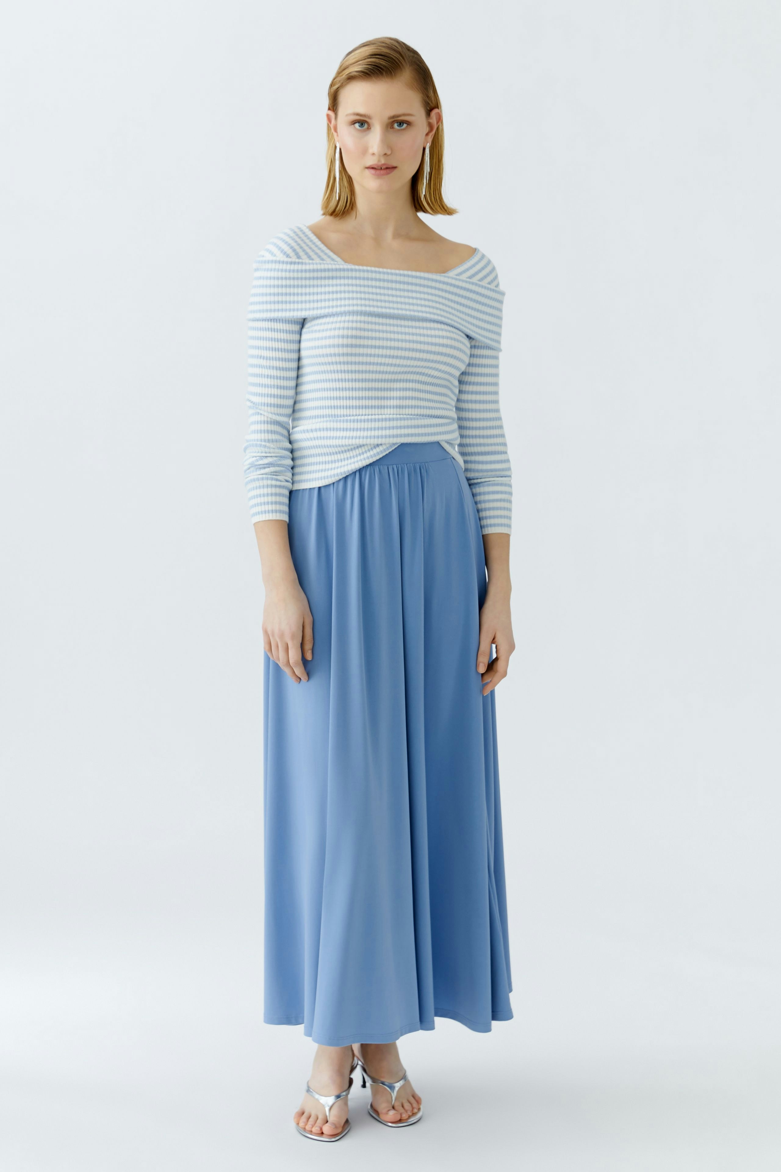 Casual women's pullover: Woman in a striped blue and white pullover with a relaxed fit.