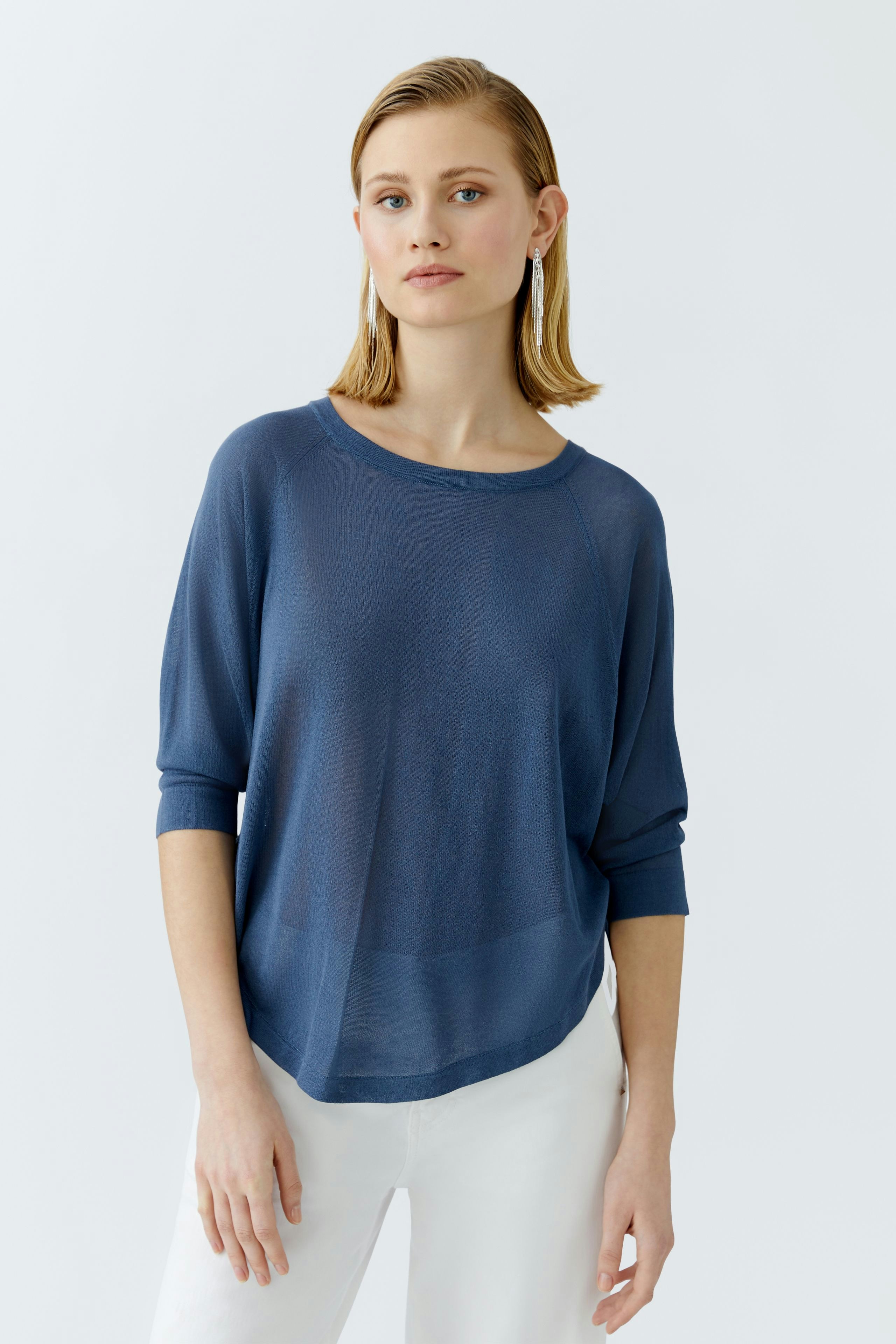 Damen-Pullover: Junge Frau in einem blauen, lässigen Pullover mit weitem Schnitt und 3/4-Ärmeln.