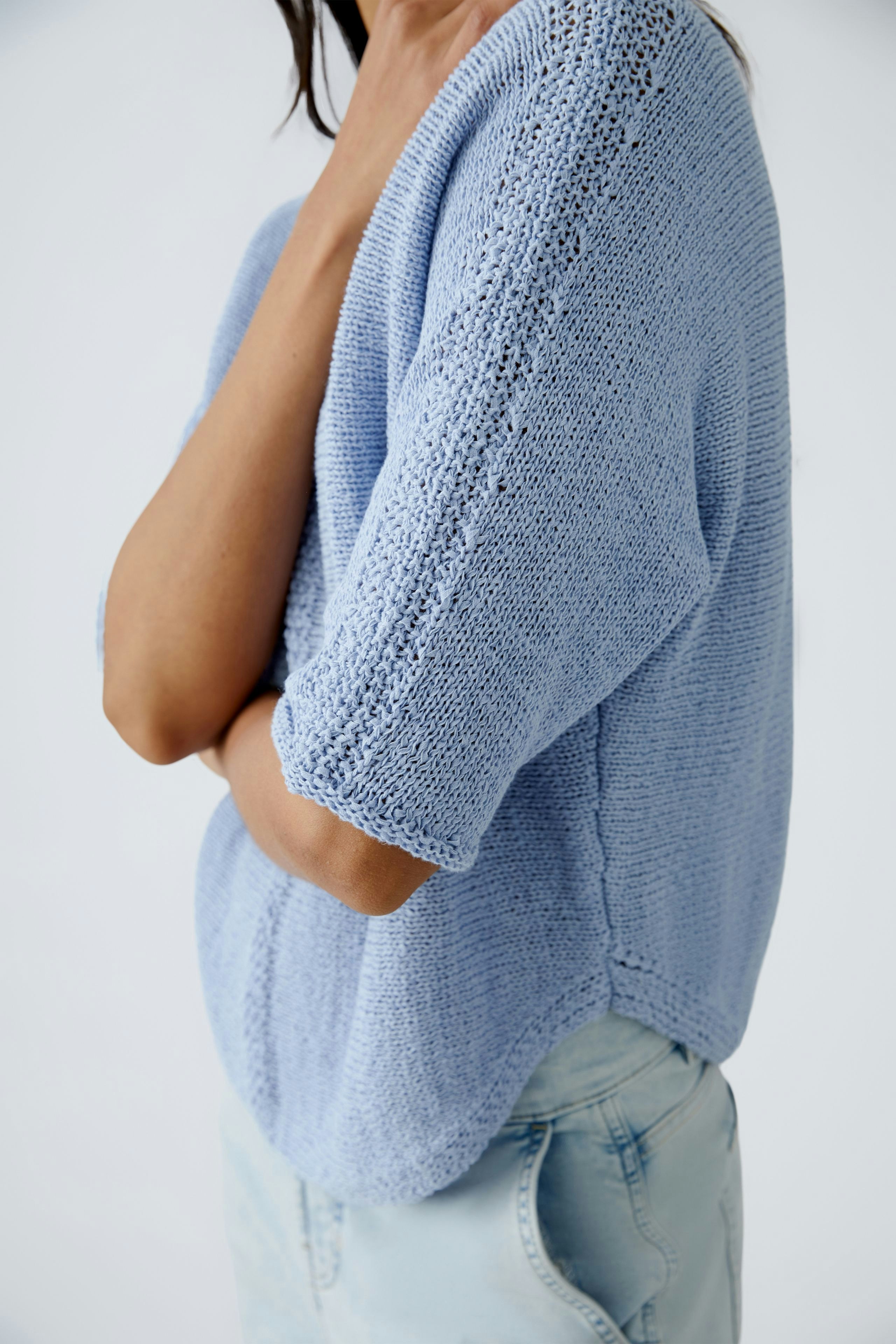 Stylish women's pullover in light blue, featuring a relaxed fit and short sleeves.