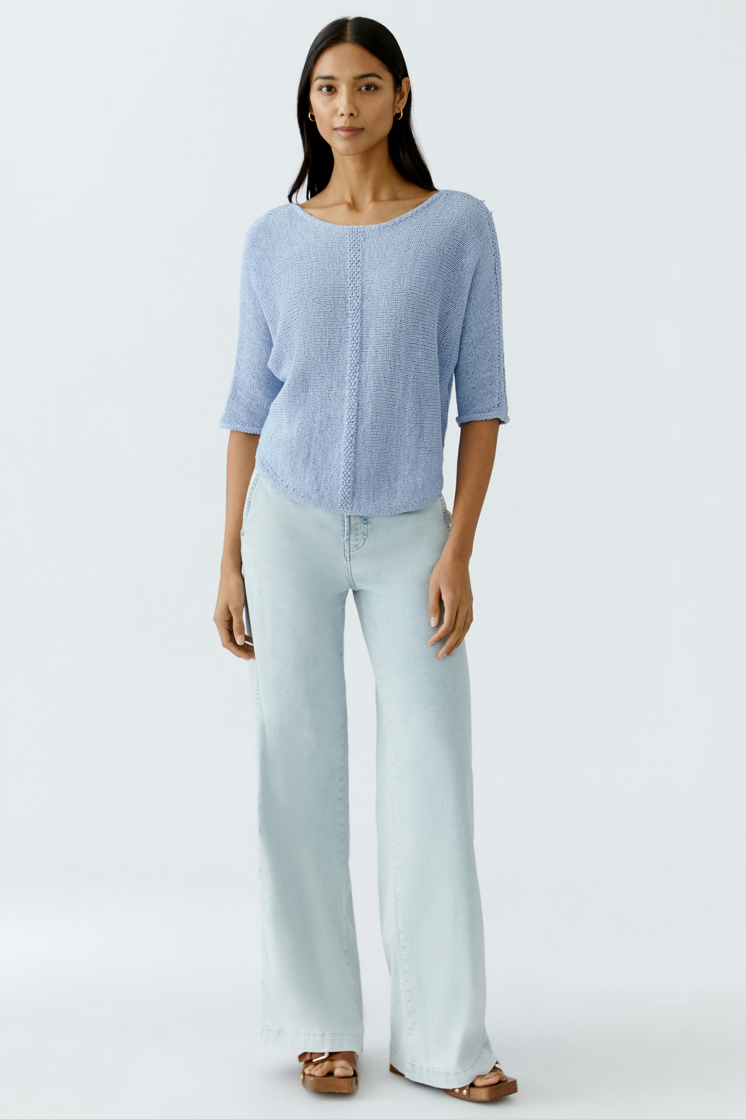 Light blue pullover: Woman in a relaxed fit, three-quarter sleeve pullover paired with light jeans.