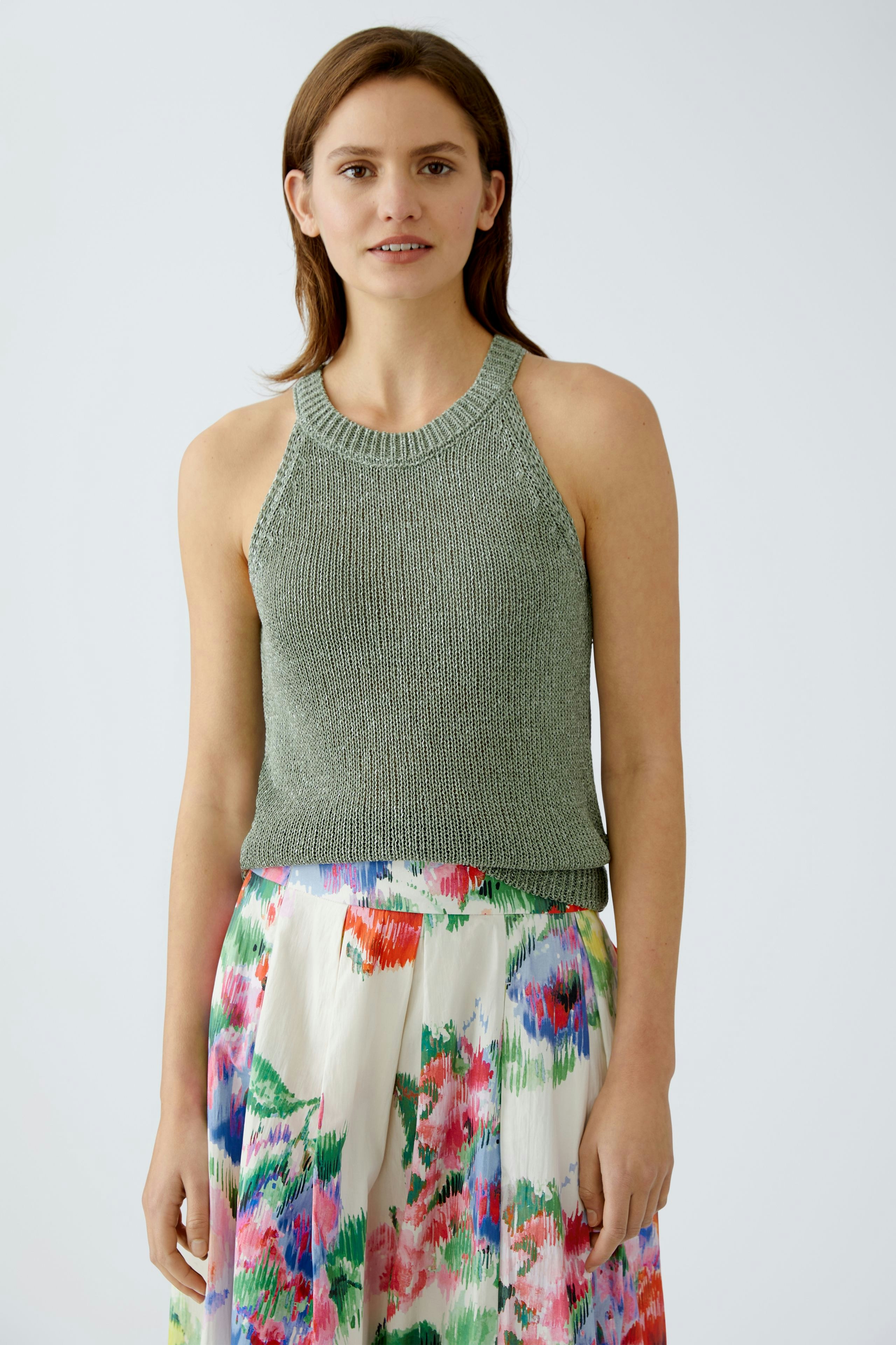 Elegantes Damen-Top in sanftem Grün, kombiniert mit einem farbenfrohen, blumigen Rock.