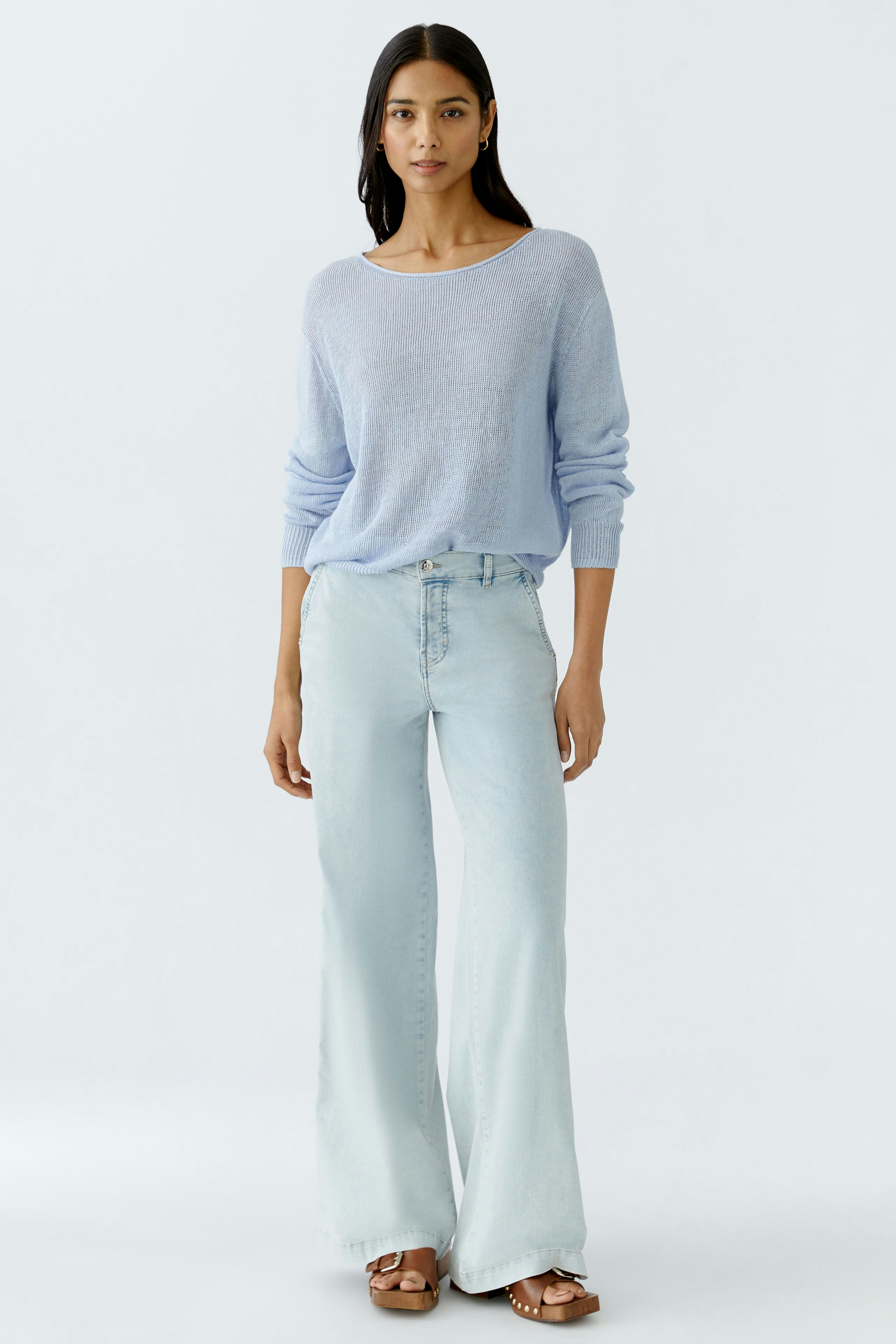 Light blue pullover: Woman in a relaxed fit, long-sleeve pullover paired with light jeans.