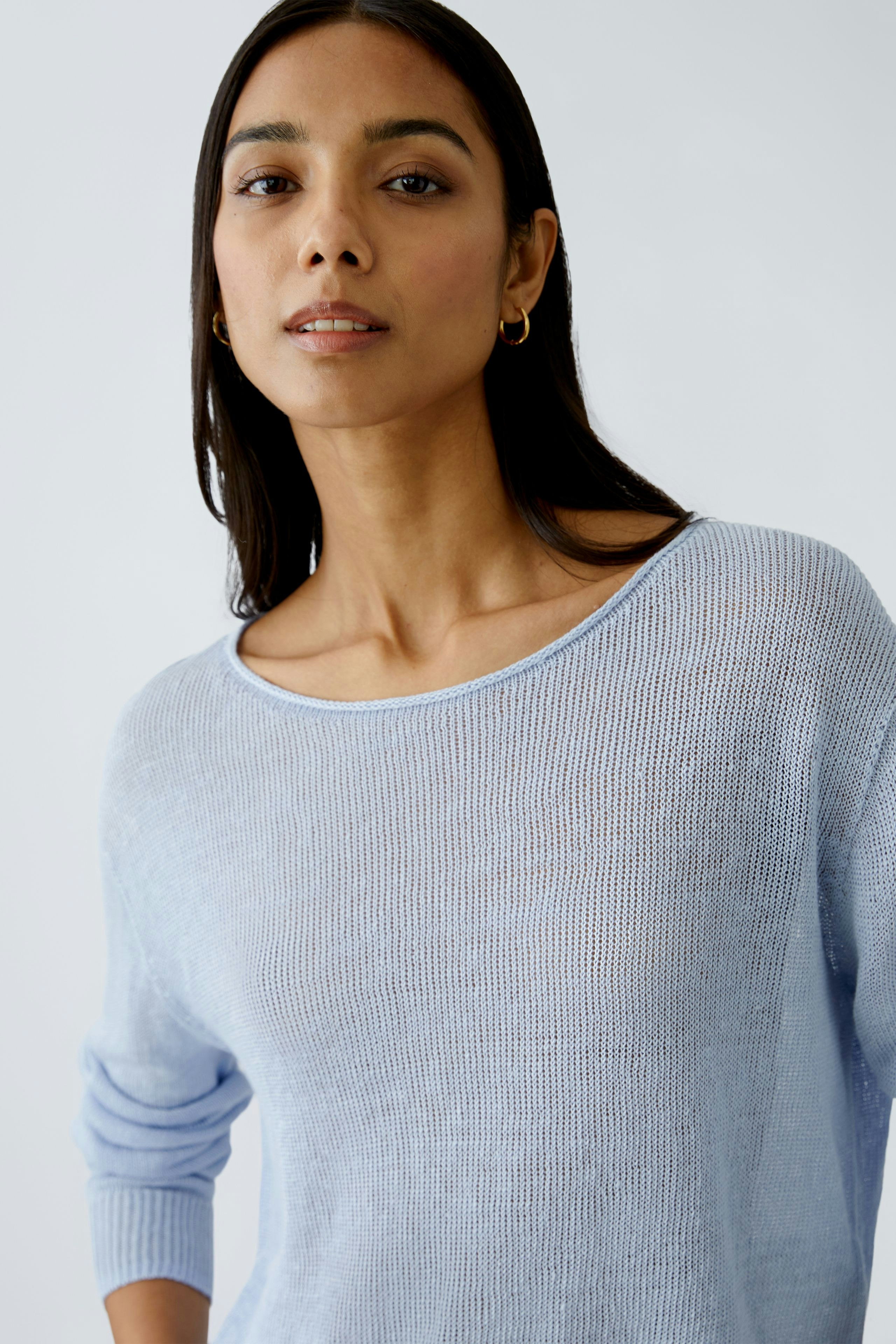Light blue pullover: Confident woman in a soft, lightweight pullover with a relaxed fit.