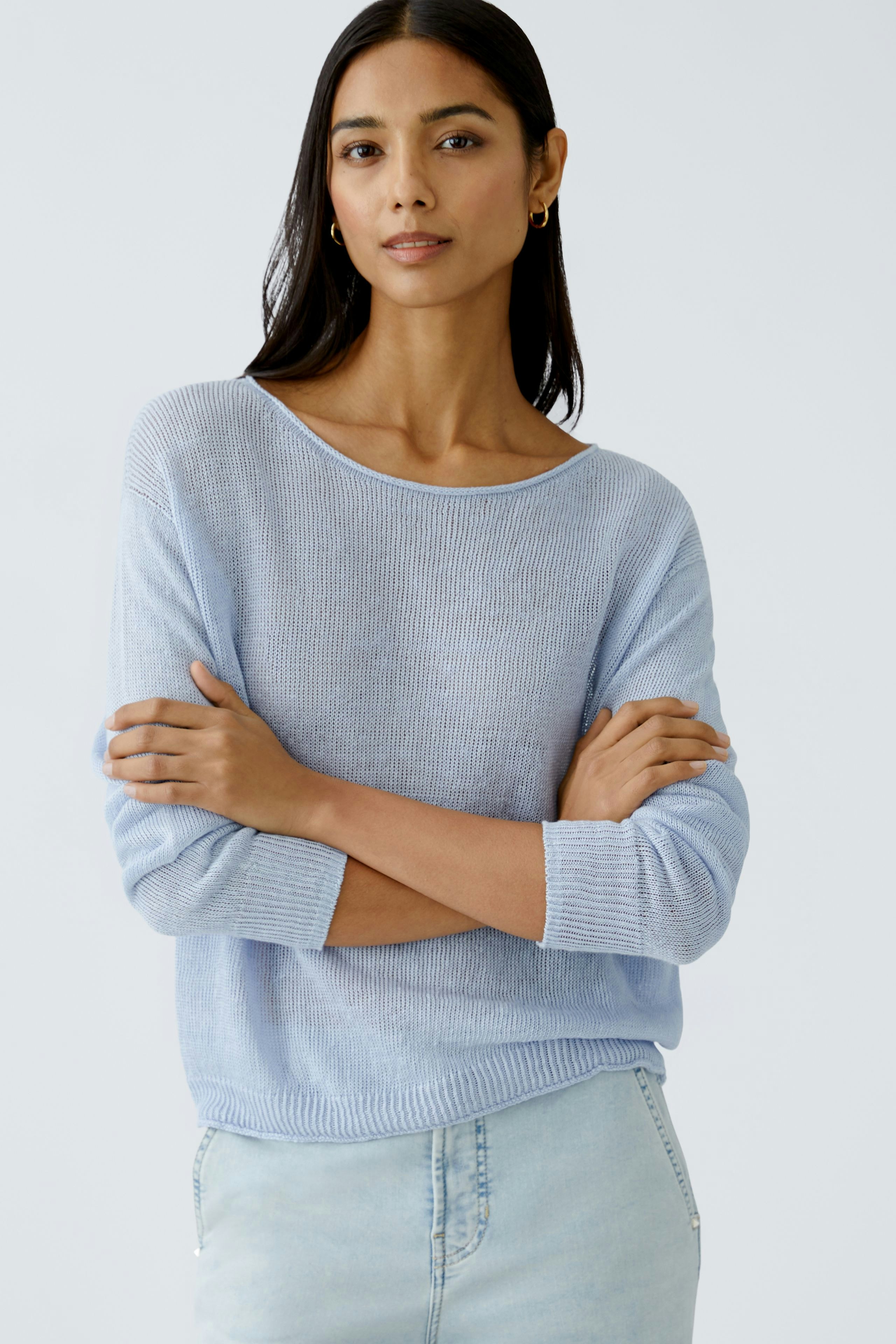 Stylish women's pullover: A woman in a light blue pullover with a relaxed fit and three-quarter sleeves.