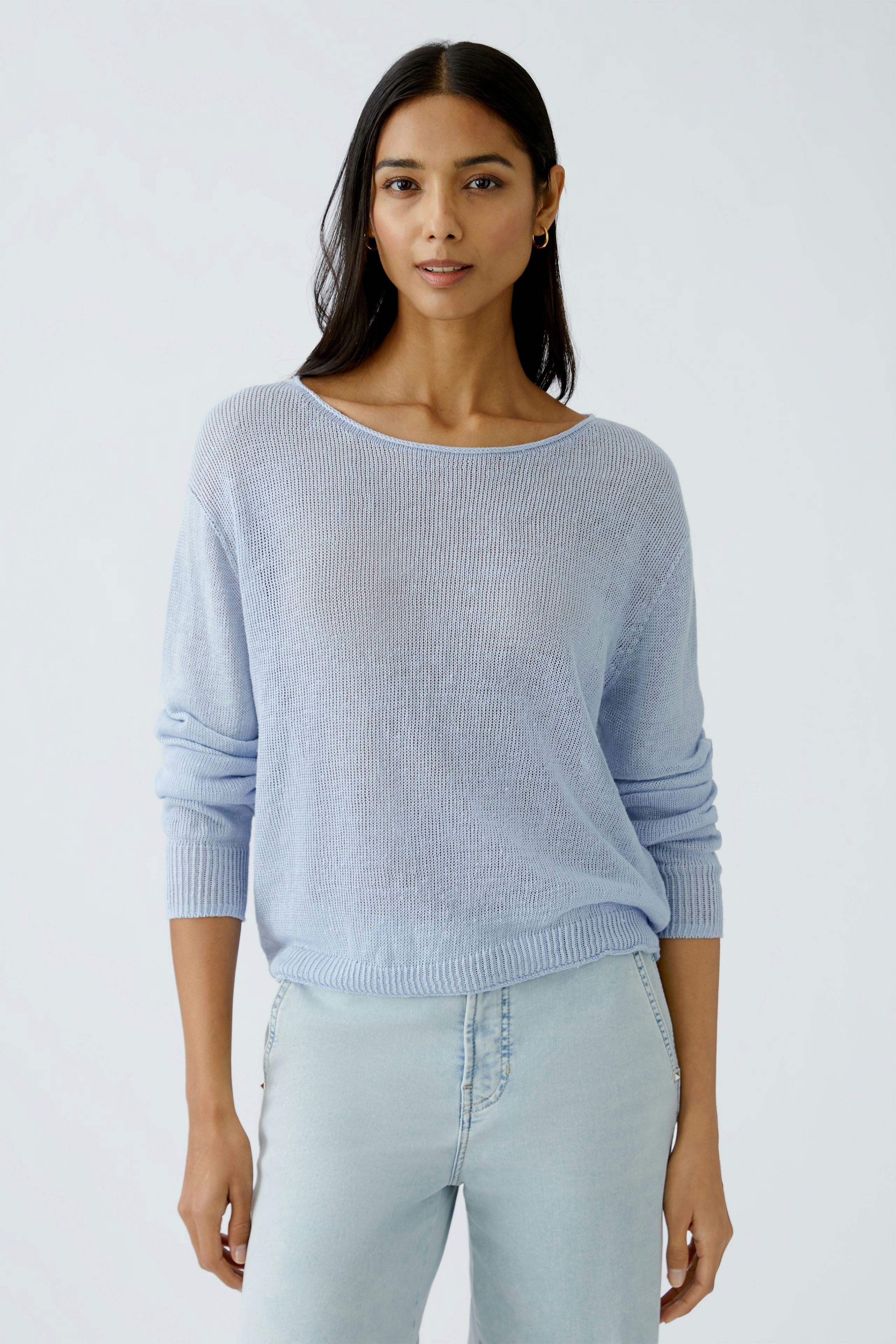 Light blue pullover: Woman in a relaxed fit, soft knit pullover paired with light jeans.