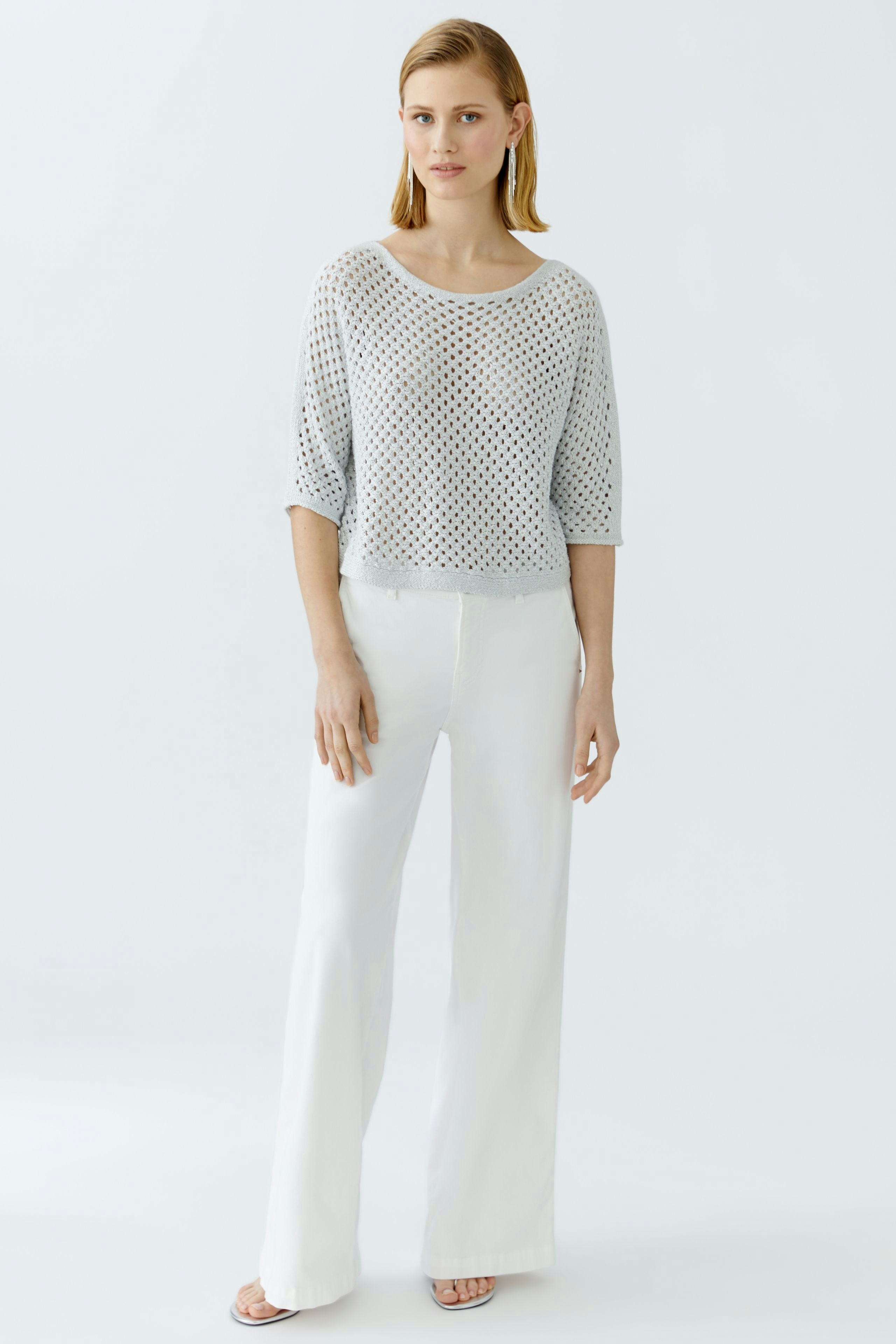 Casual women's pullover: A woman in a light, airy pullover with a loose fit and wide sleeves.