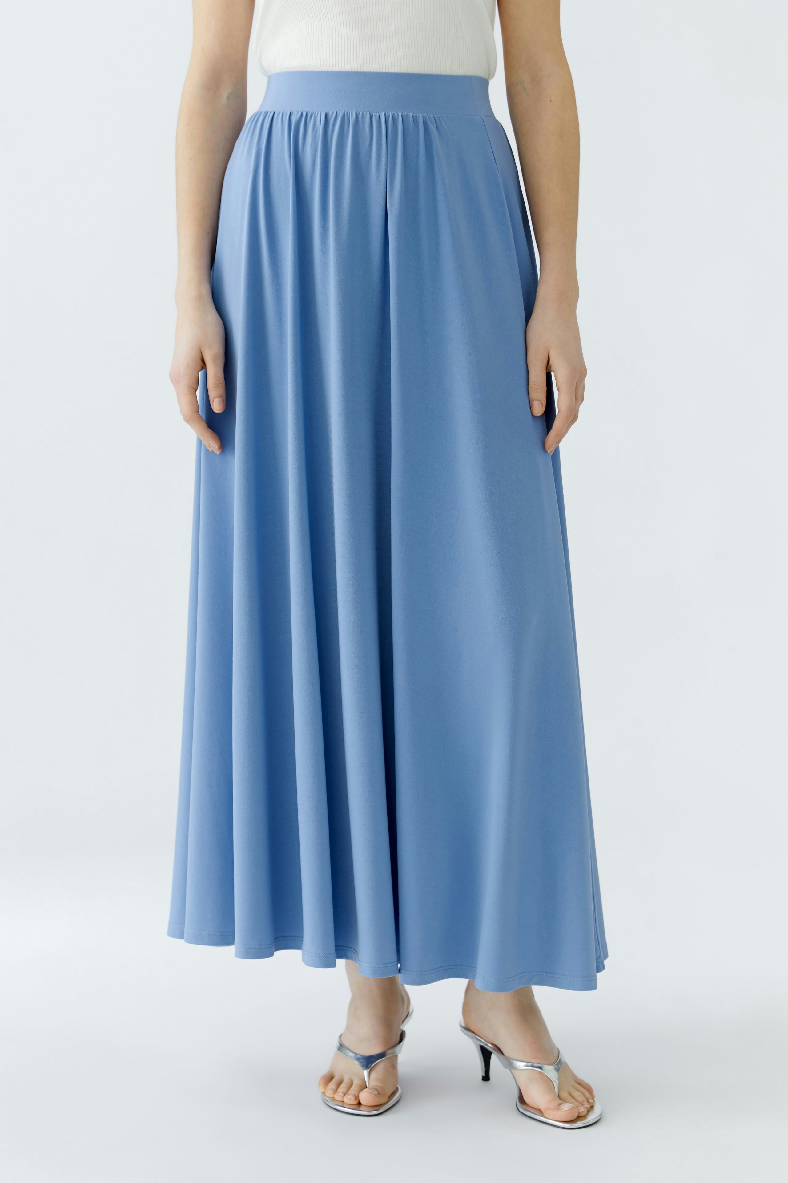 Luftiger A-Linien-Rock in Blau: Frau trägt den Rock mit einem schlichten Oberteil und Sandalen.