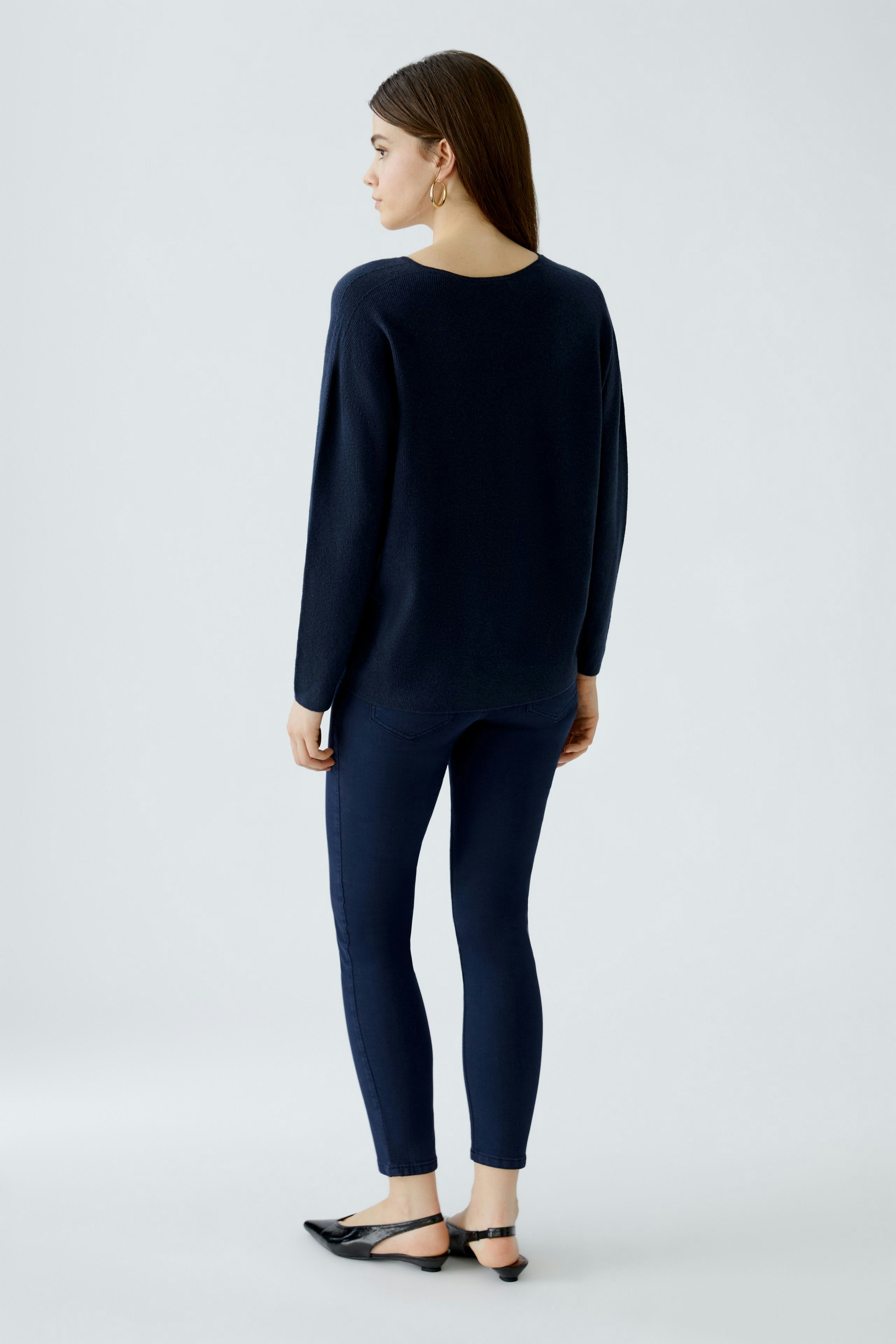 Casual women's pullover: A woman in a navy pullover paired with matching leggings, showcasing a relaxed style.